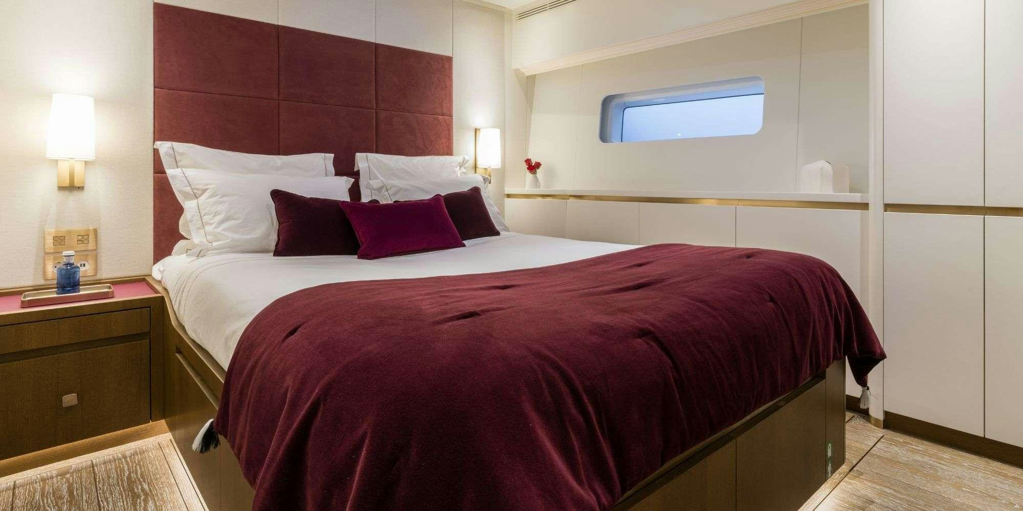 a bed with red pillows aboard FANCY Yacht for Charter