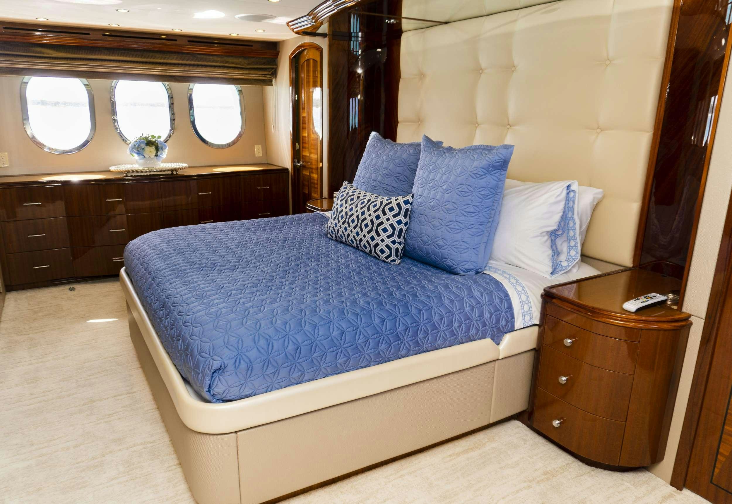 a bed with blue sheets aboard GAIL FORCE II Yacht for Charter