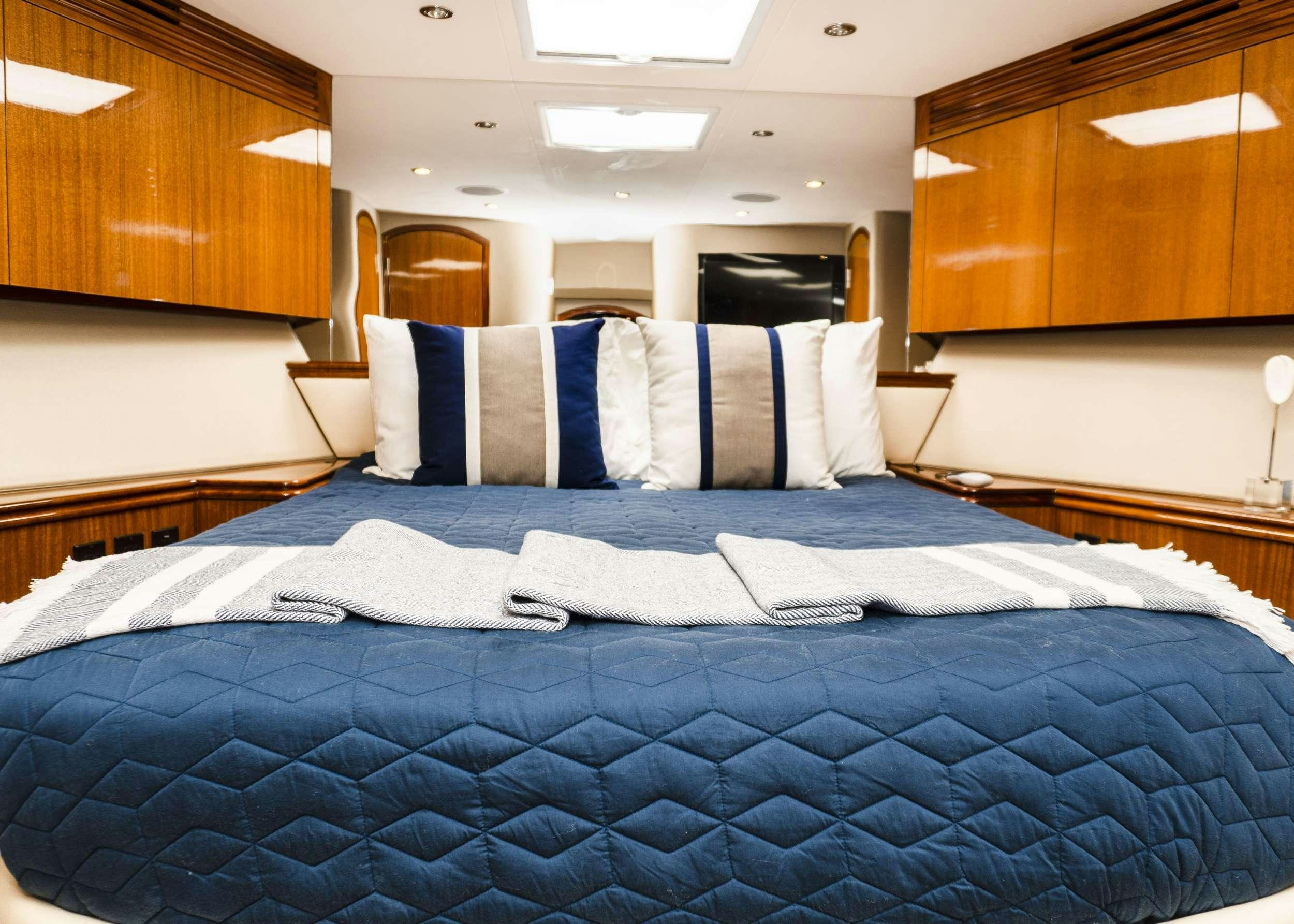 a bed with blue sheets aboard GAIL FORCE II Yacht for Charter