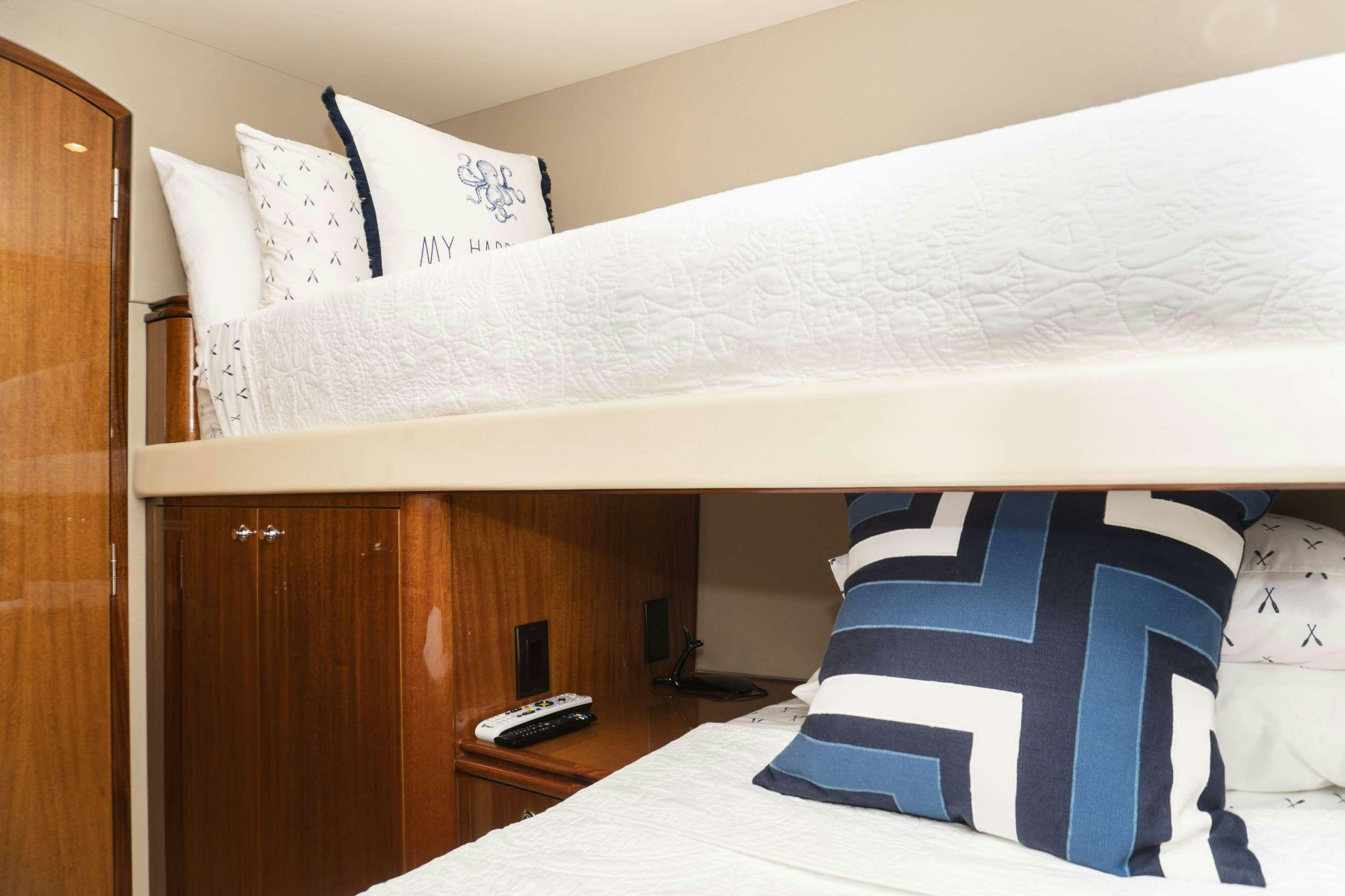 a bed with white sheets and pillows aboard GAIL FORCE II Yacht for Charter