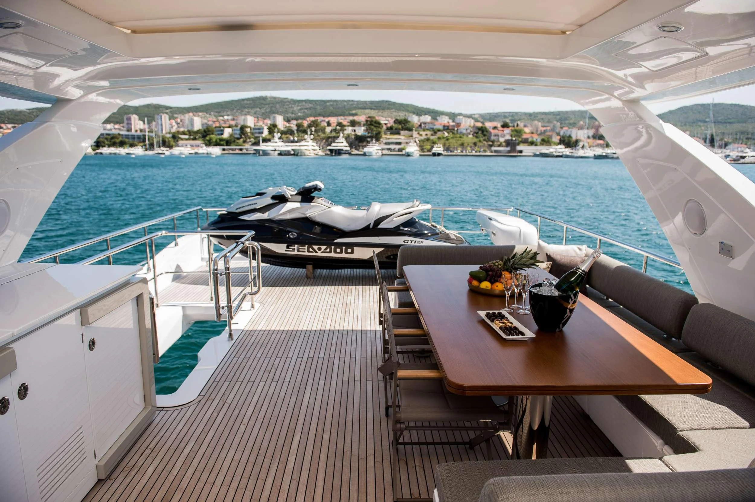 a table and chairs on a deck overlooking a body of water aboard ALYSS Yacht for Charter