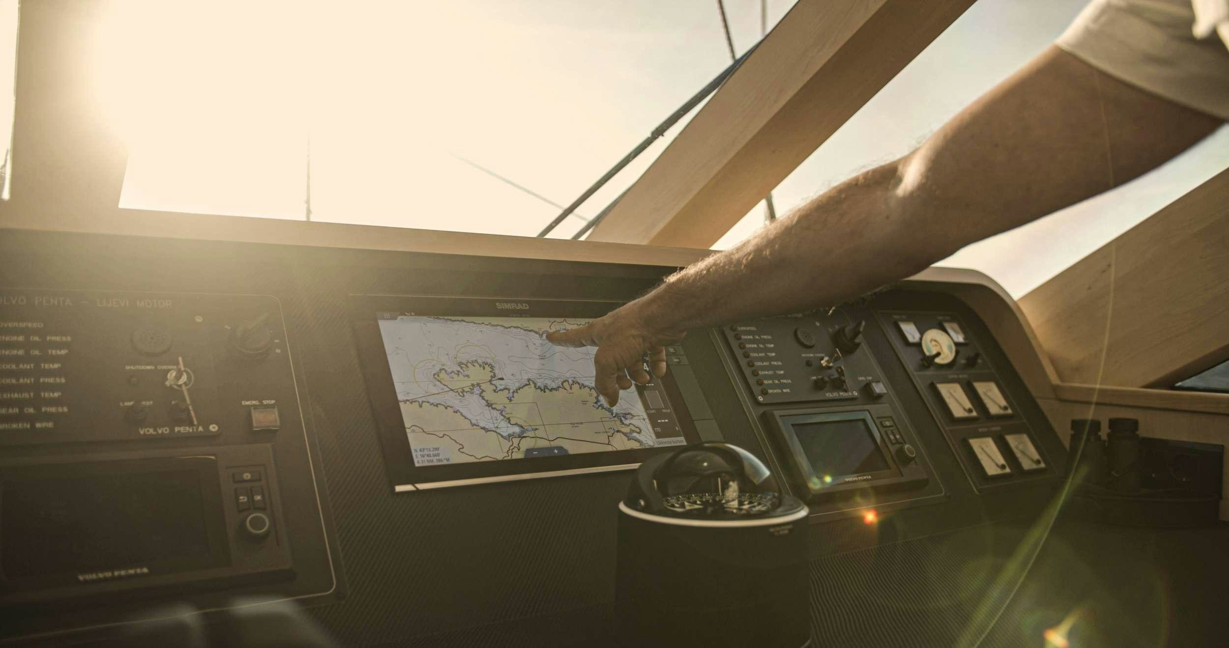a hand holding a book in a cockpit aboard M/S AURUM SKY Yacht for Charter