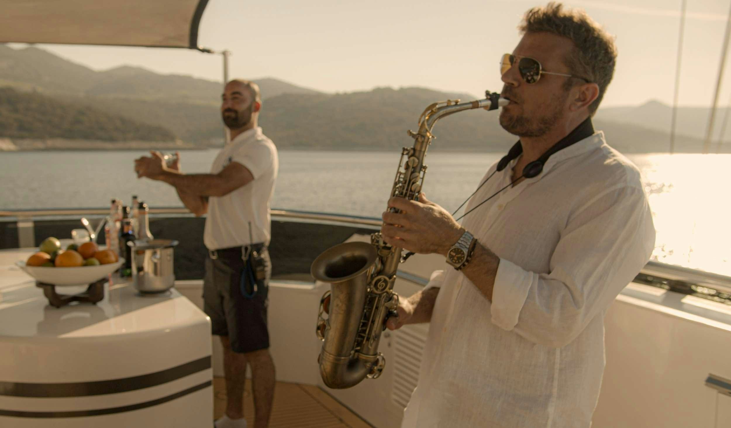 a person pouring a drink into a glass aboard M/S AURUM SKY Yacht for Charter
