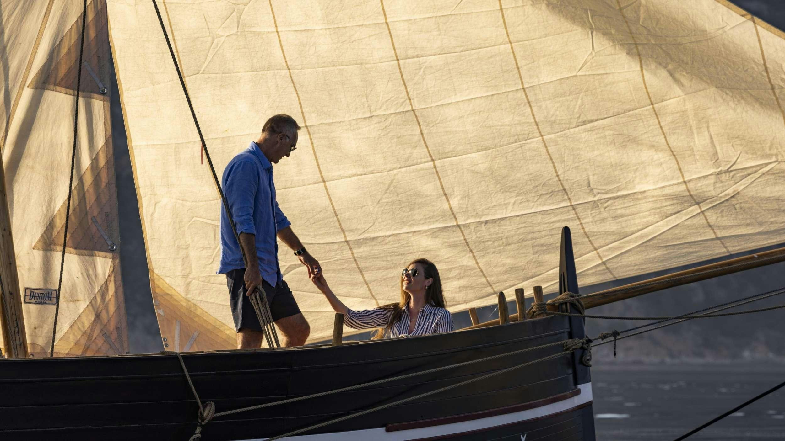 a man and a woman standing on a sailboat aboard M/S AURUM SKY Yacht for Charter
