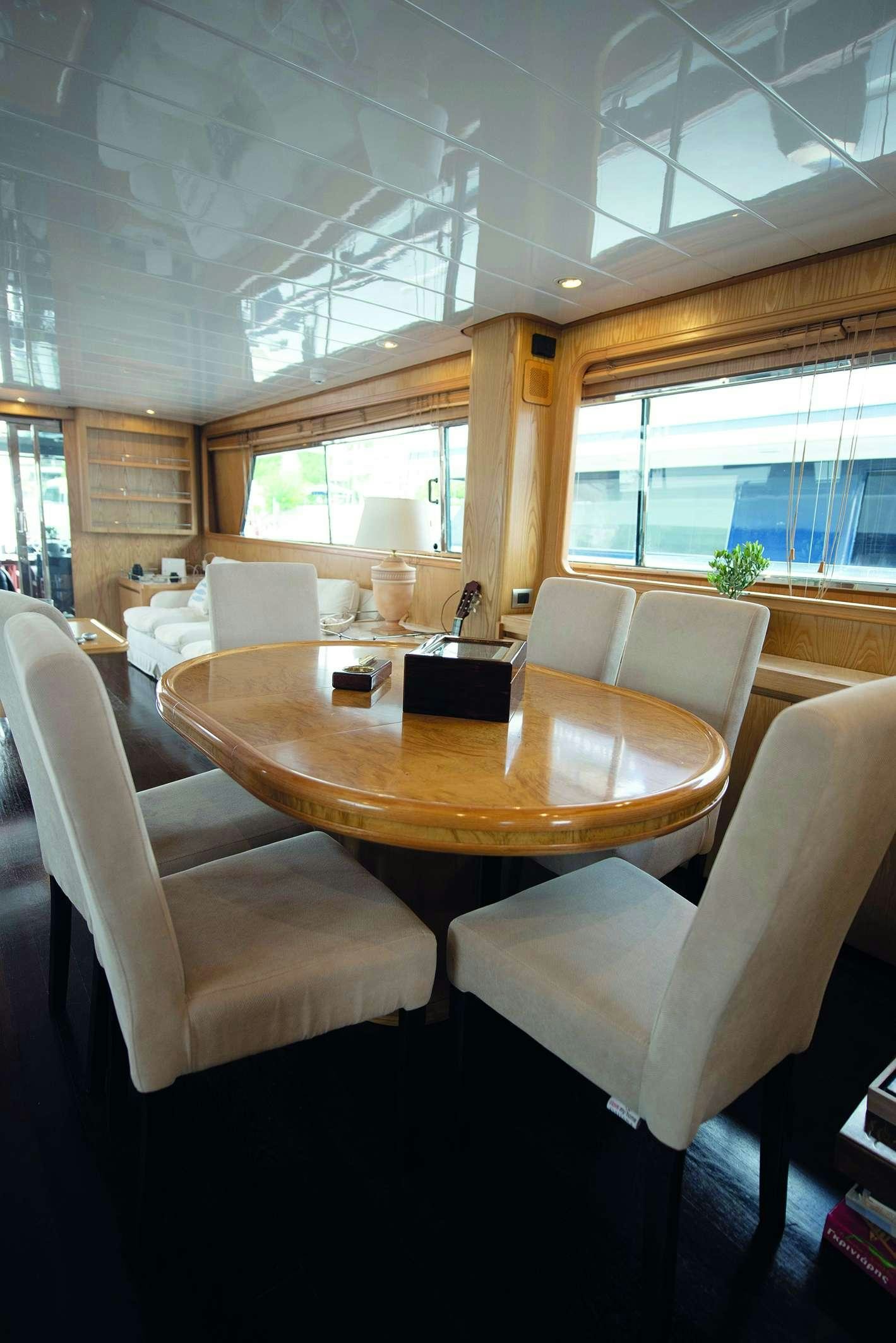 a room with a table chairs and a couch aboard KISS Yacht for Charter