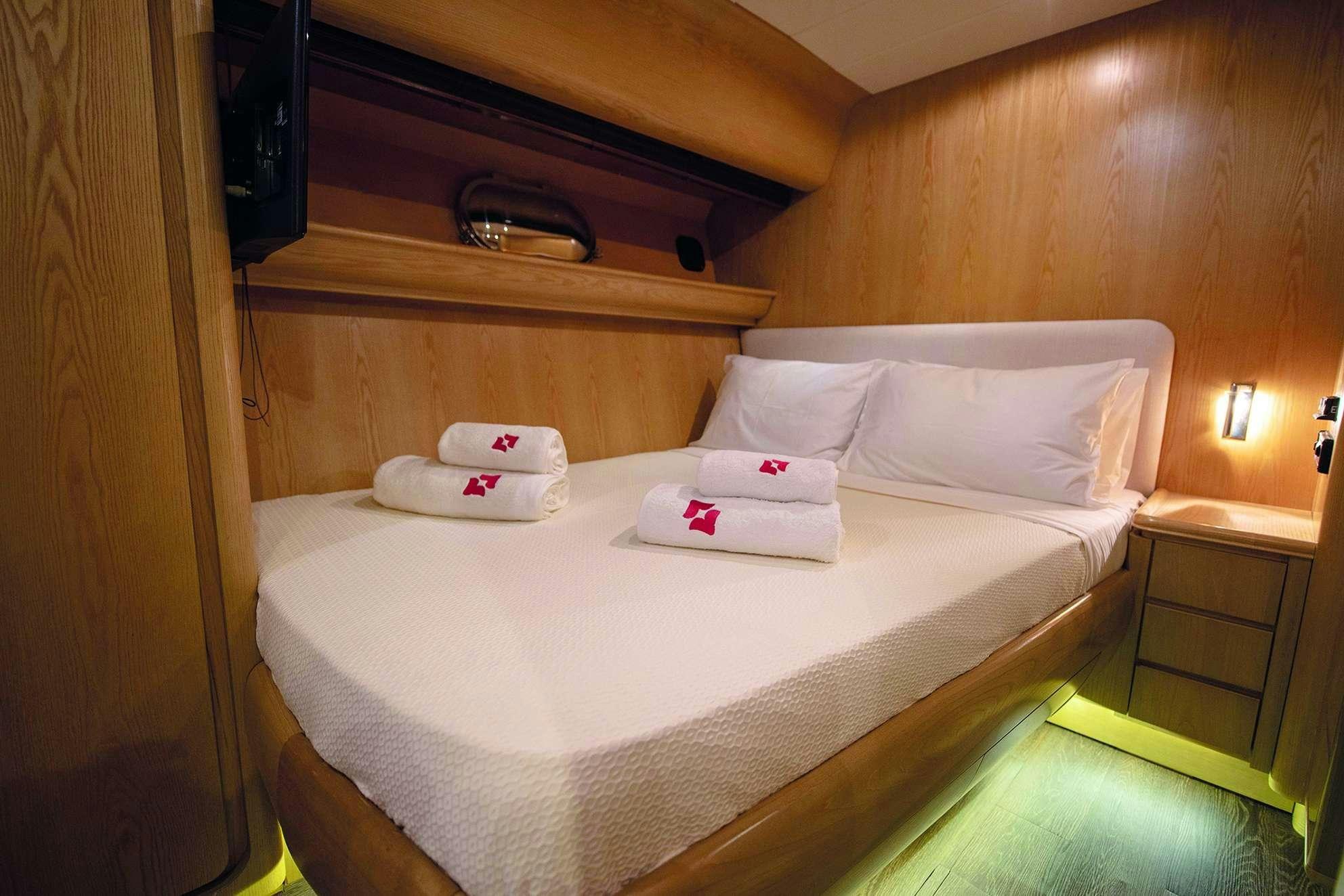 a bed with a white sheet and pillows on it aboard KISS Yacht for Charter