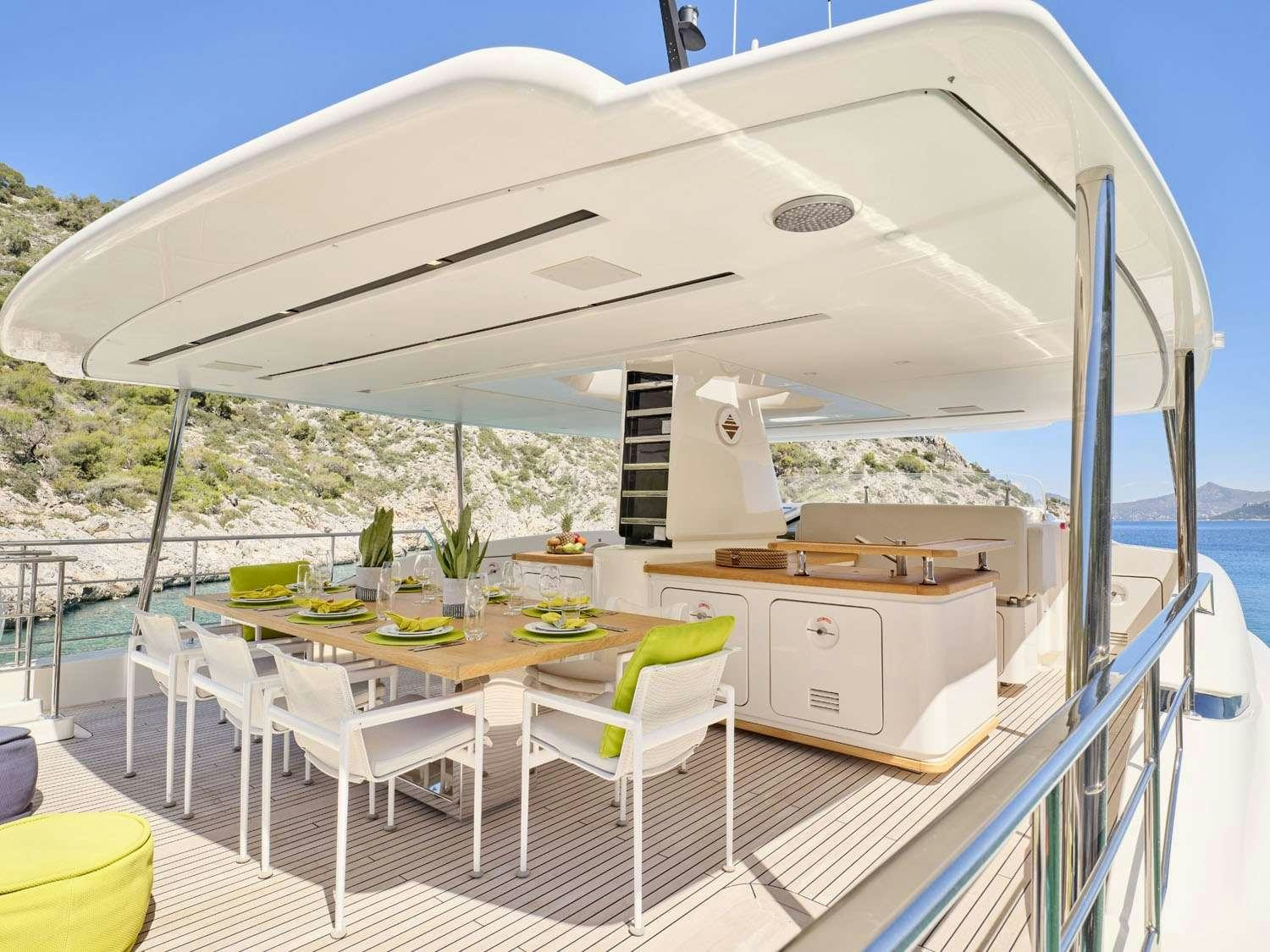 a deck with tables and chairs aboard FLOR Yacht for Charter