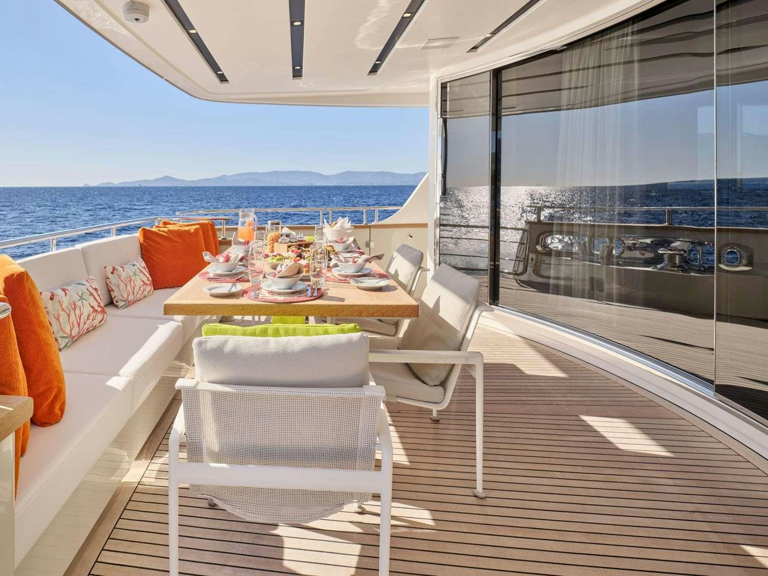 a balcony with a table and chairs aboard FLOR Yacht for Charter