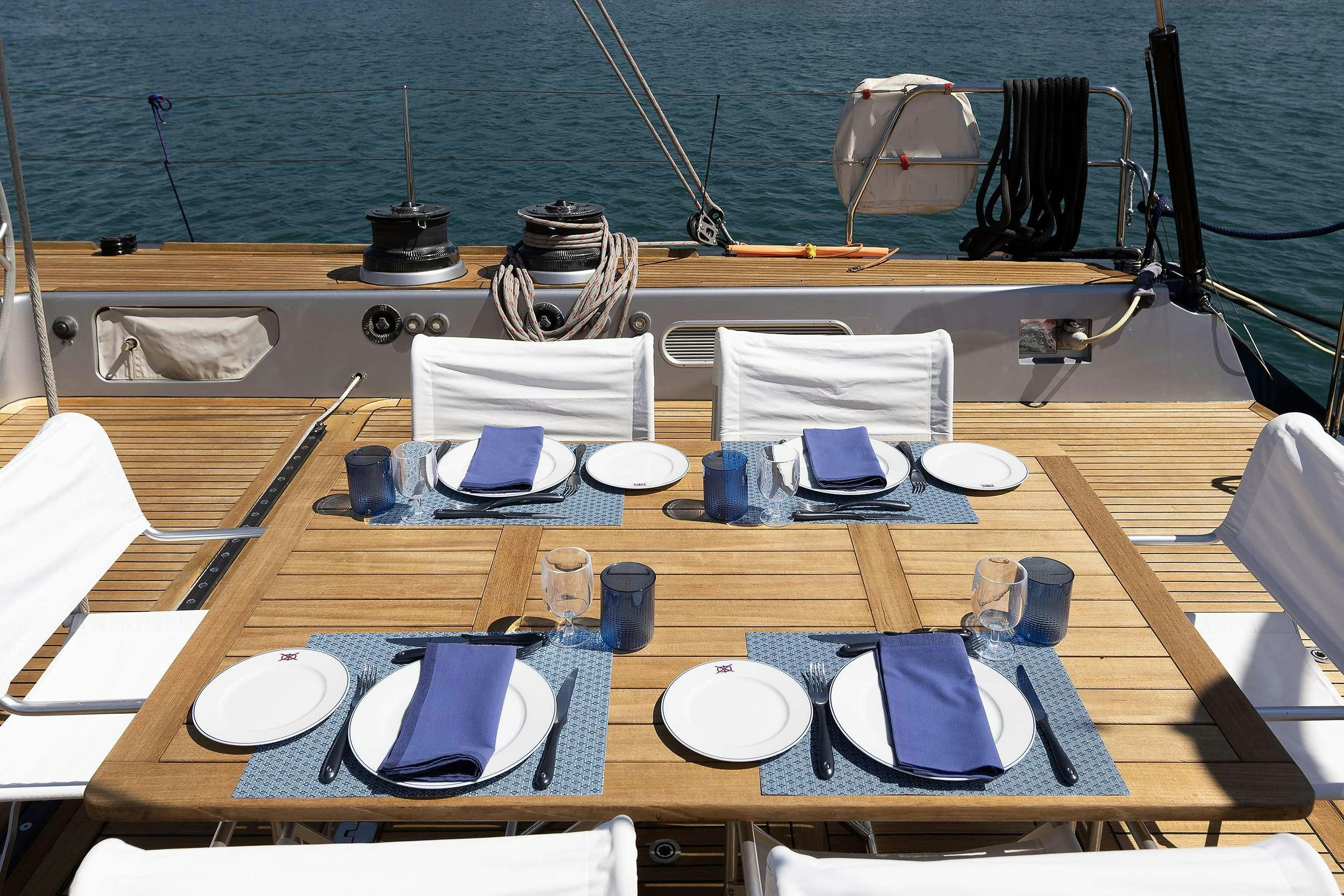 a table with plates and cups on it aboard MELITI Yacht for Charter