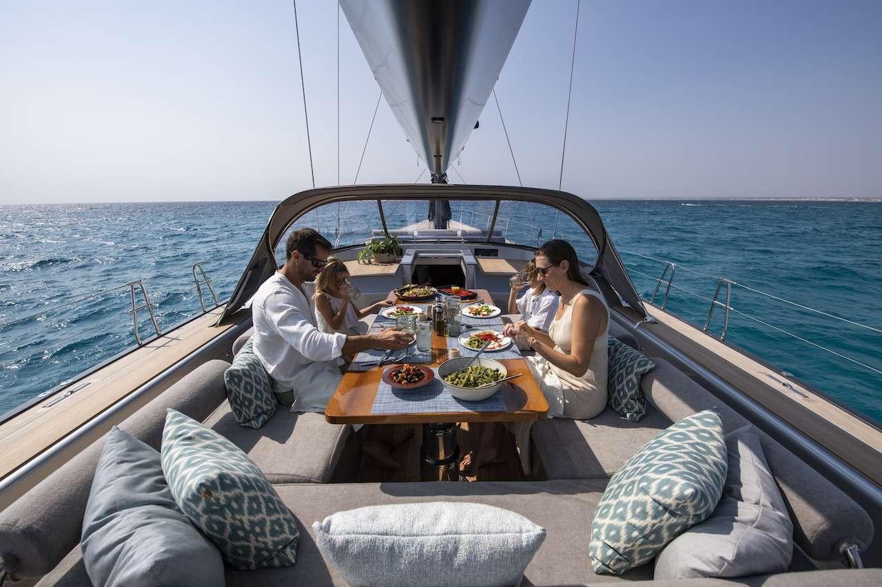 a group of people sitting around a table on a boat aboard ONYX Yacht for Charter