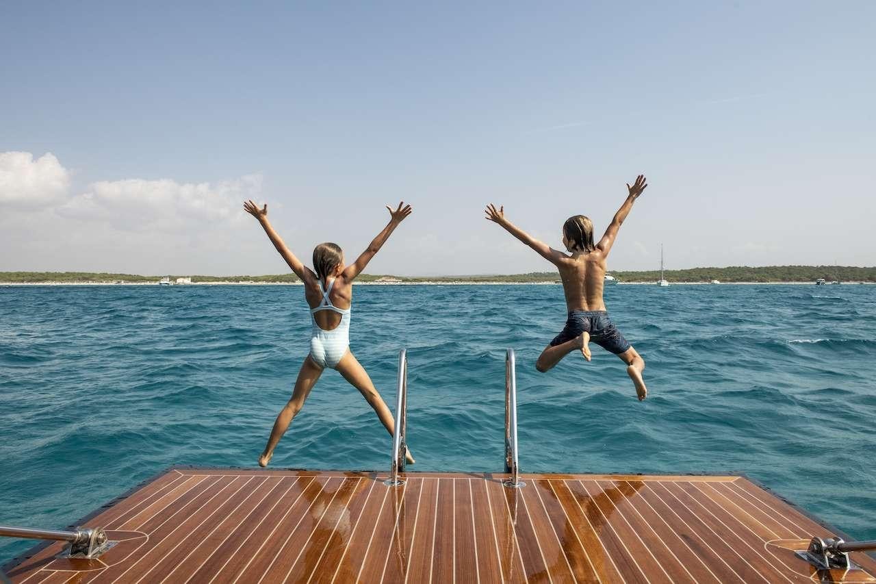 two women jumping into water aboard ONYX Yacht for Charter