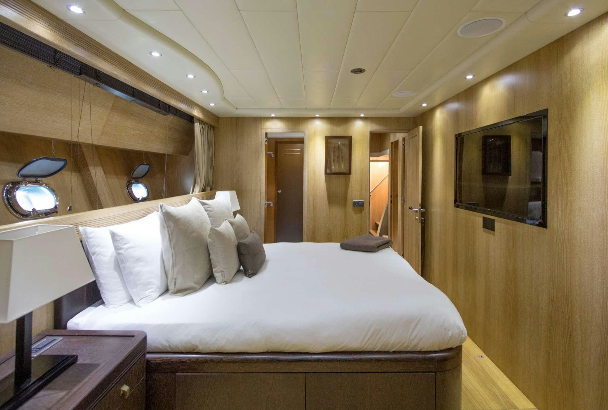 a bed with white sheets aboard JFF Yacht for Charter