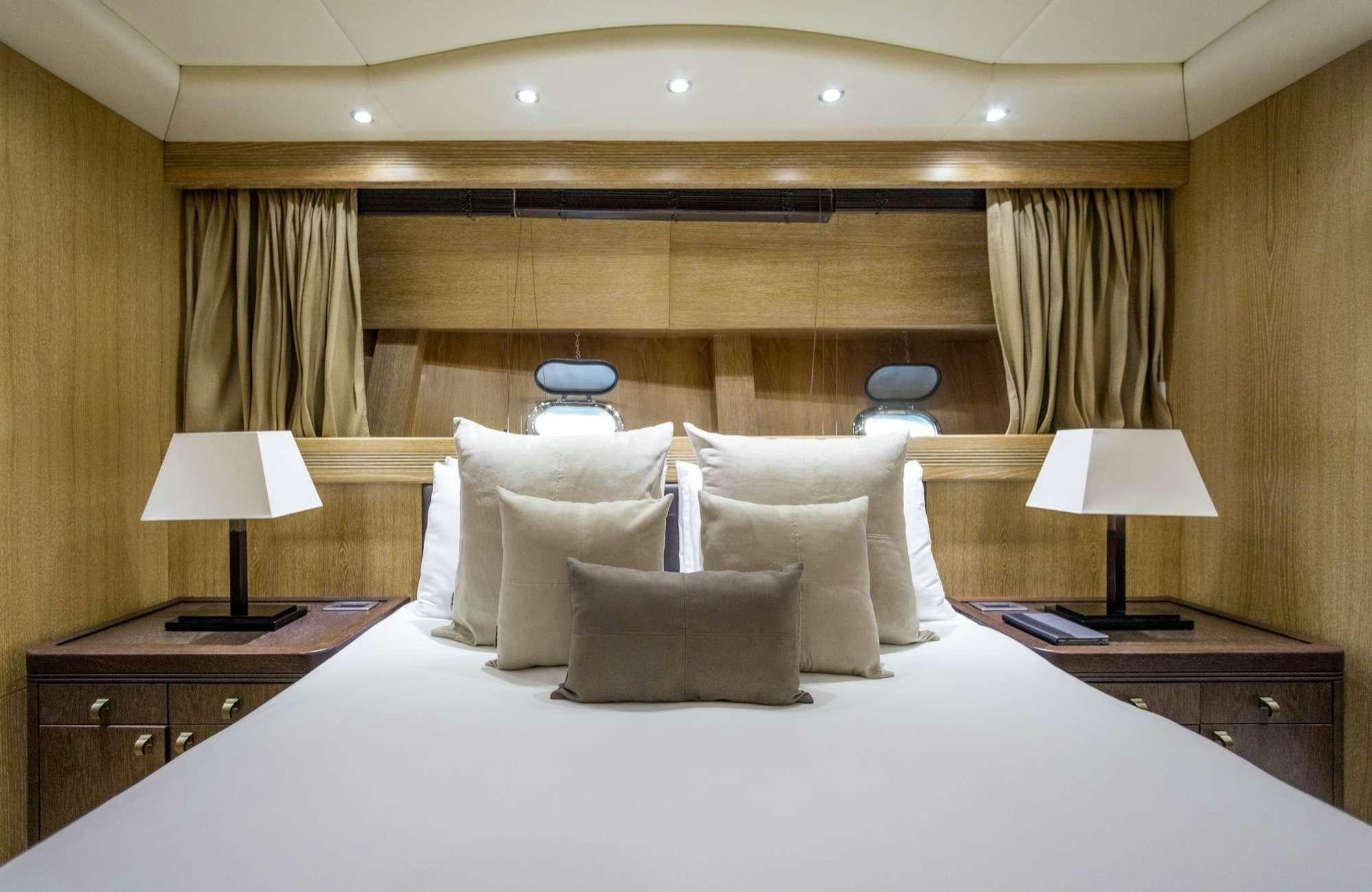 a bed with pillows and lamps aboard JFF Yacht for Charter