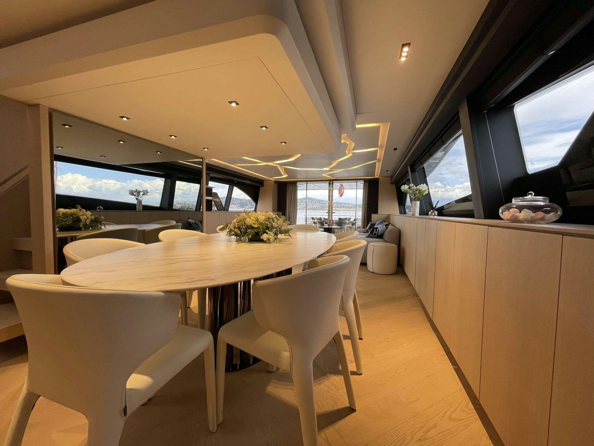 a kitchen with a table and chairs aboard FERRETTI 881 RPH Yacht for Charter