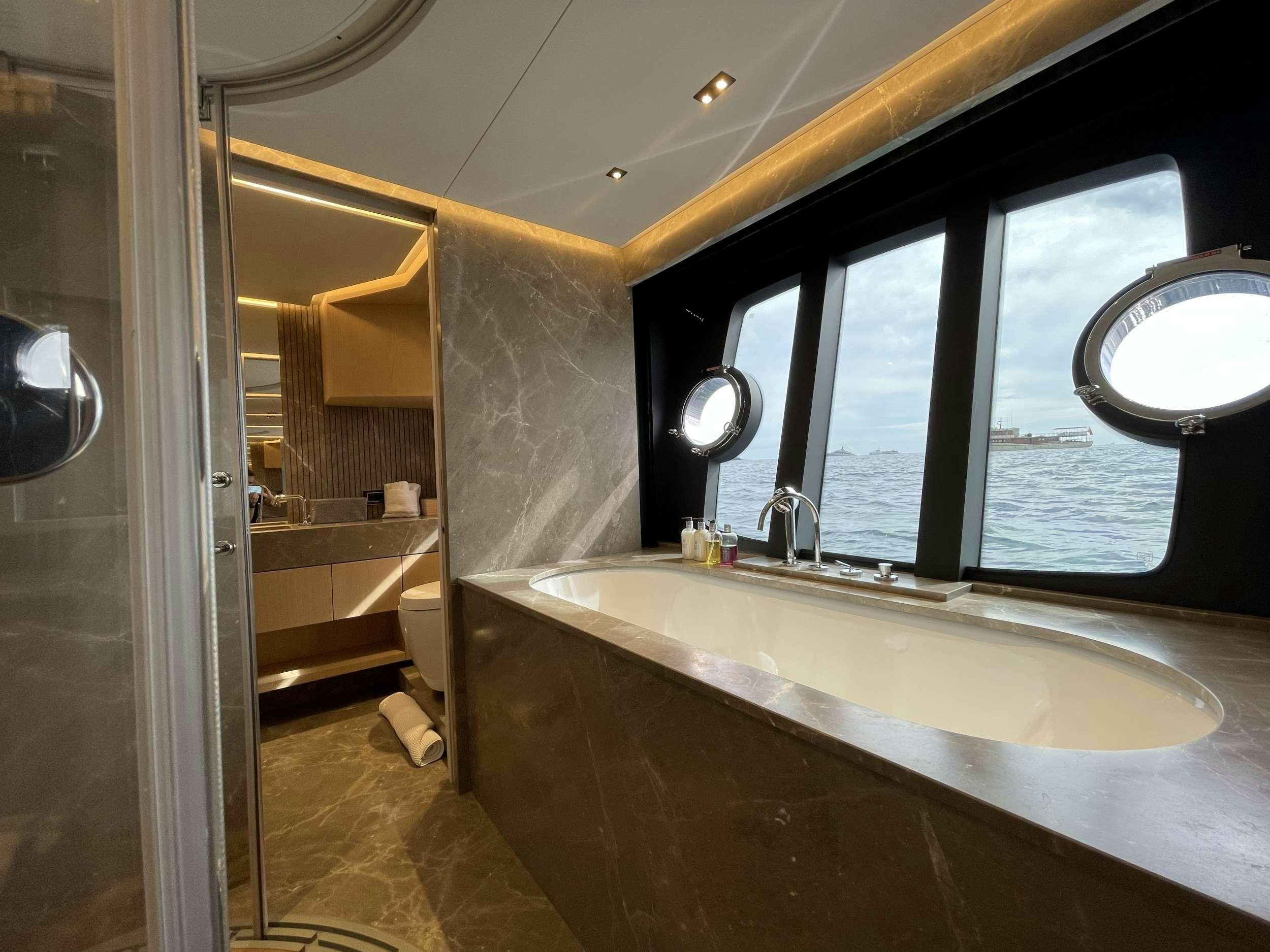 a bathroom with a large bathtub aboard FERRETTI 881 RPH Yacht for Charter