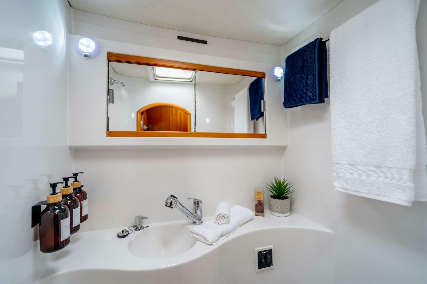 a bathroom with a mirror and a sink aboard TABULA RASA Yacht for Charter