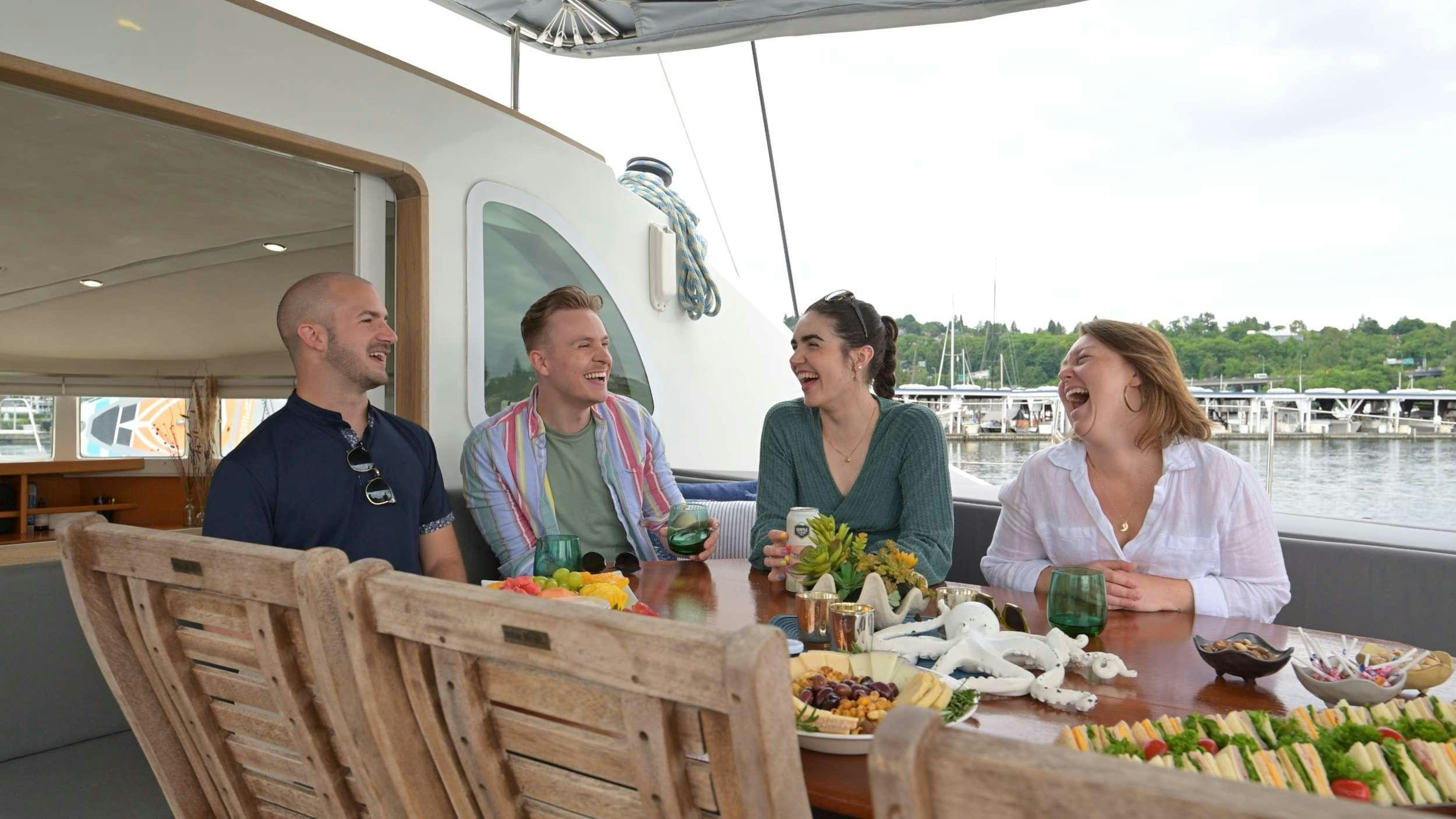 a group of people sitting at a table outside aboard TABULA RASA Yacht for Charter