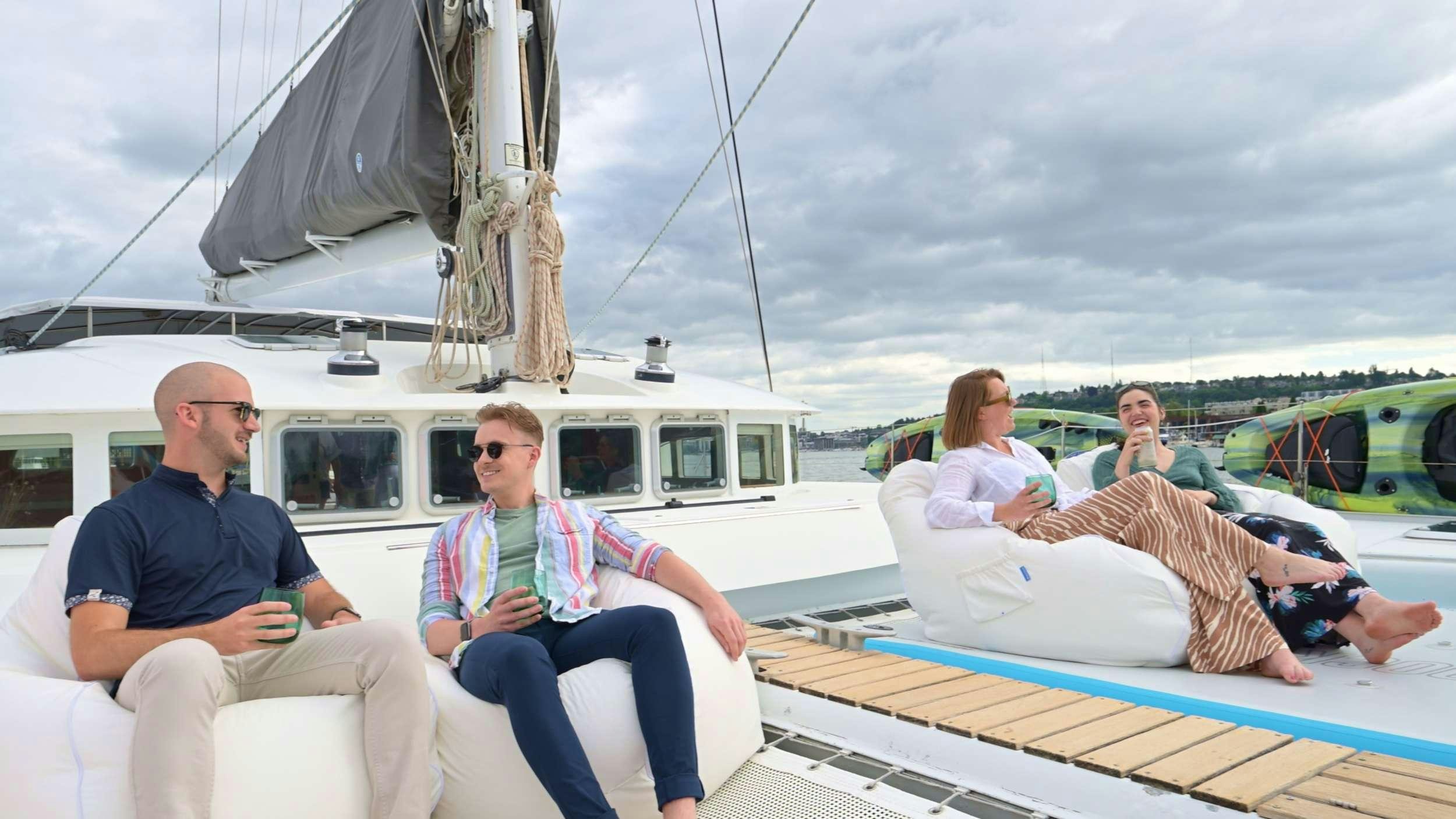 a group of people sitting on a boat with a dog on the water aboard TABULA RASA Yacht for Charter