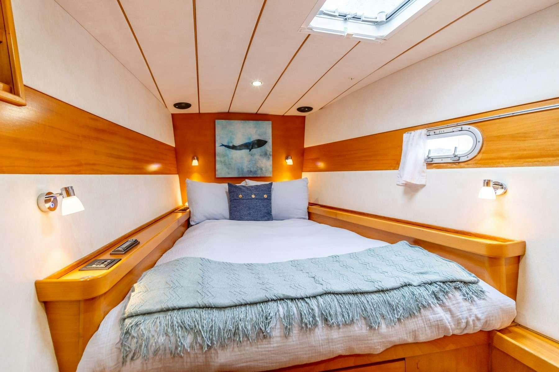 a bed with a white comforter aboard TABULA RASA Yacht for Charter