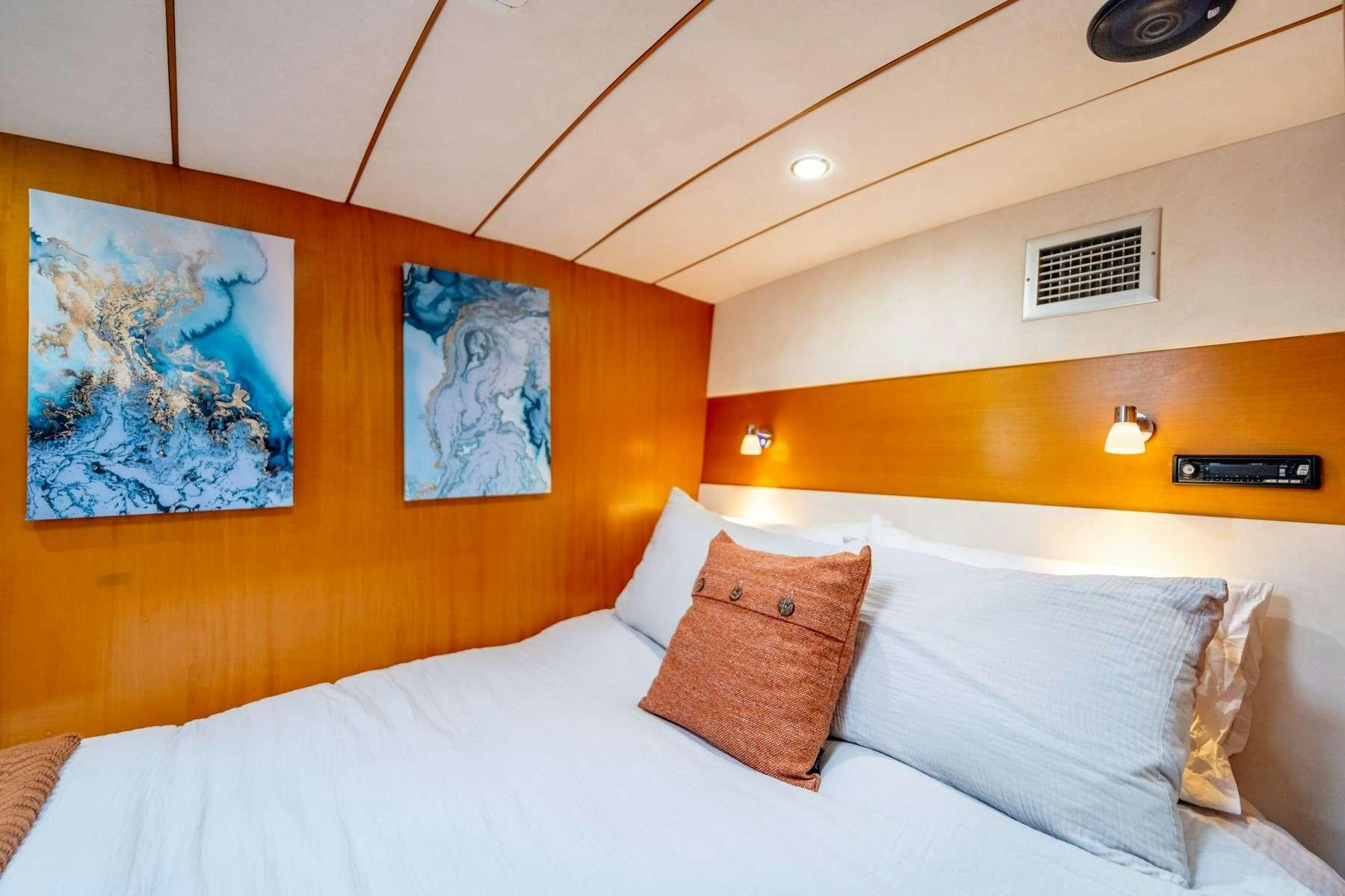 a bed with white sheets and pillows aboard TABULA RASA Yacht for Charter