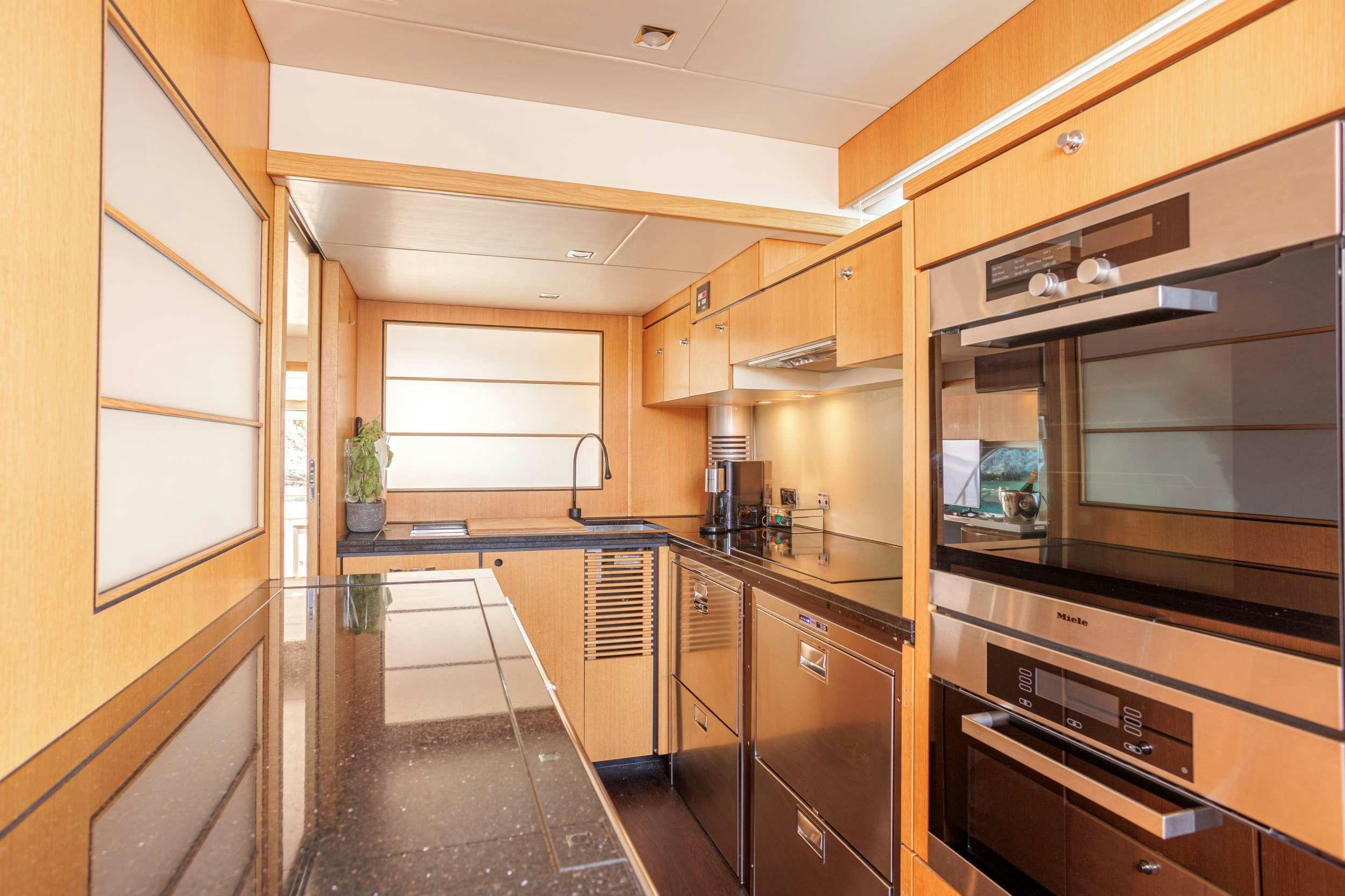 a kitchen with wooden cabinets aboard JOLIDOR Yacht for Charter