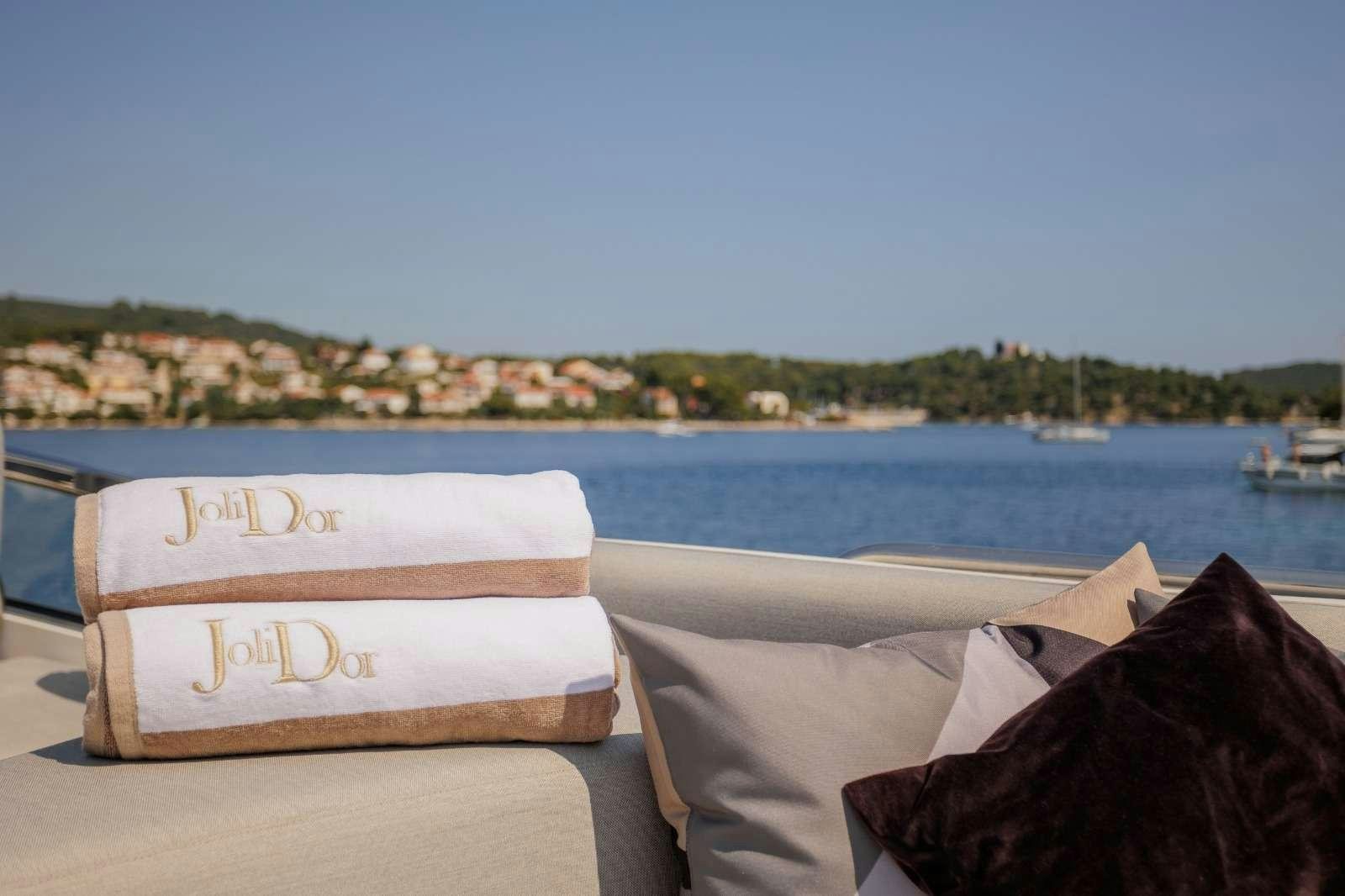 a bed with pillows on it by a body of water aboard JOLIDOR Yacht for Charter