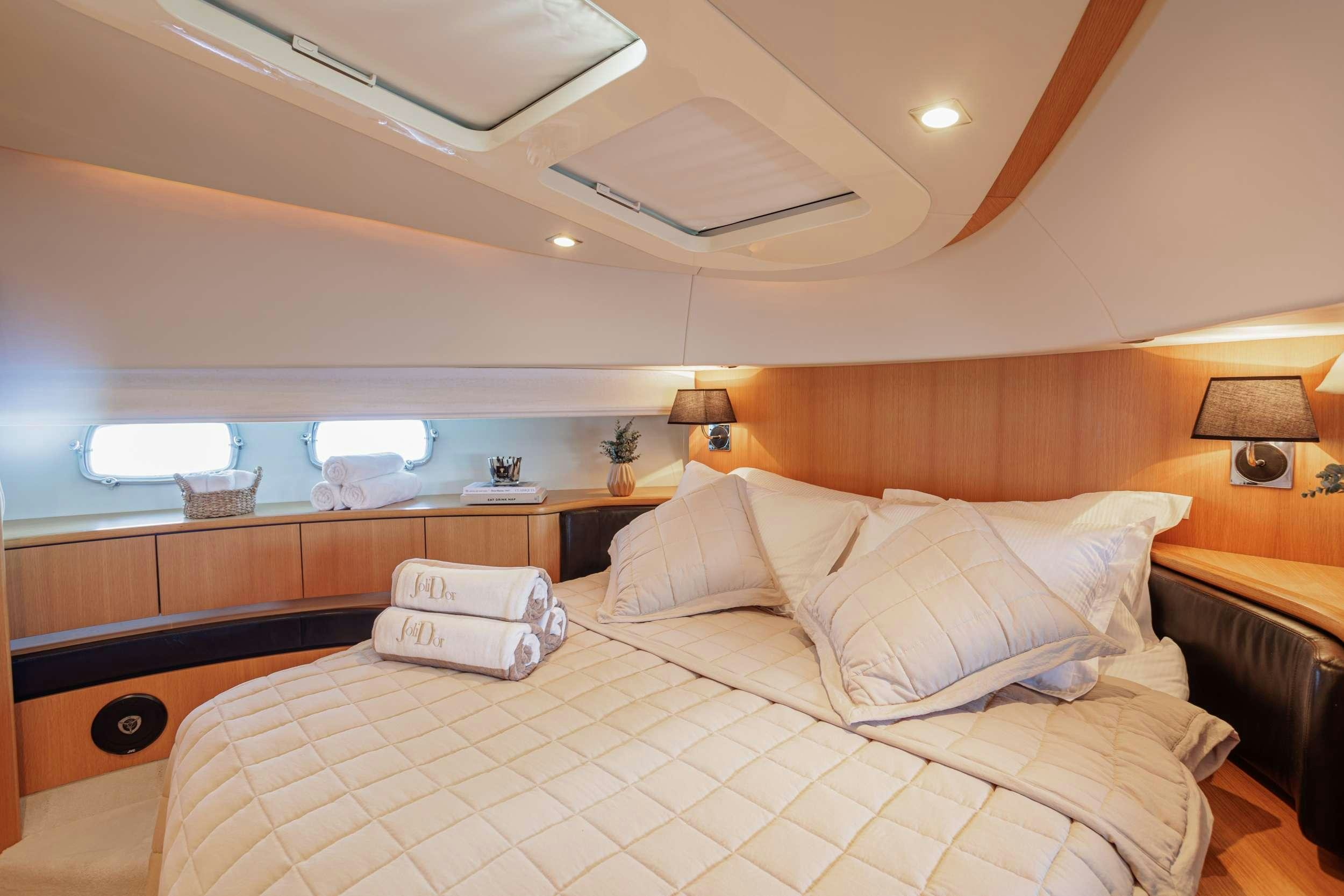 a bed with a white comforter aboard JOLIDOR Yacht for Charter