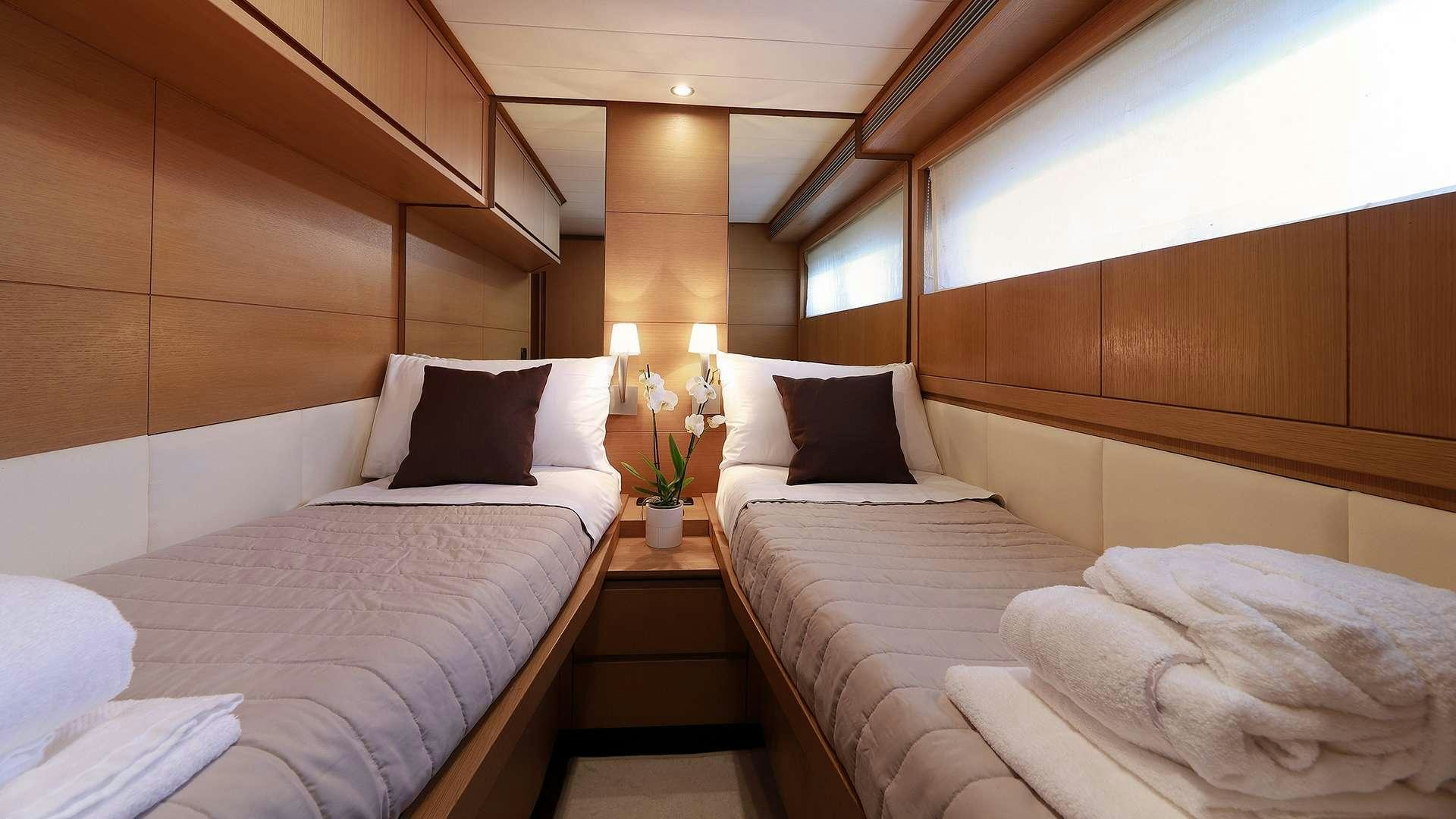 a room with beds and a table aboard PHOENIX Yacht for Charter