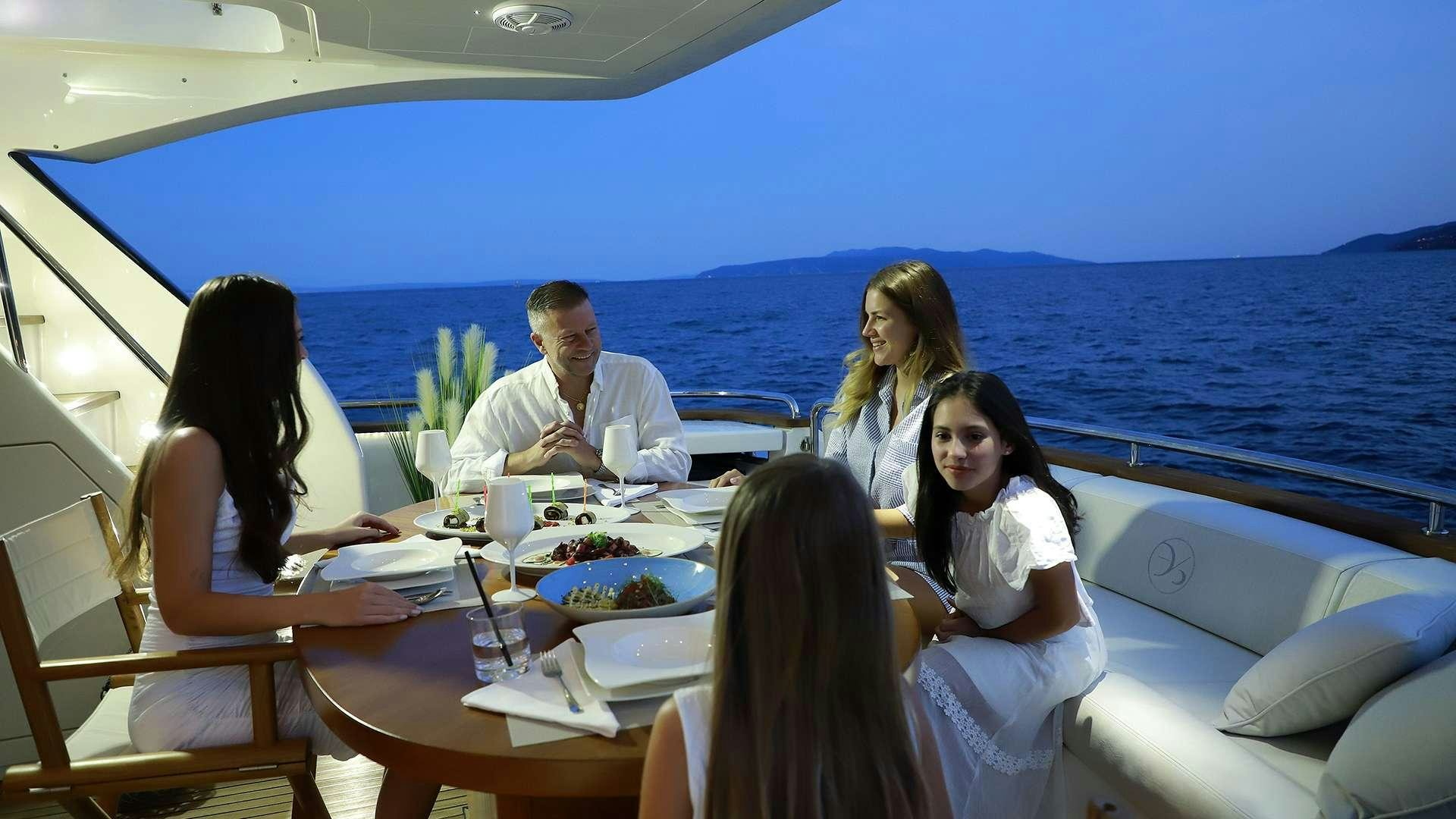 a group of people sitting around a table on a boat aboard PHOENIX Yacht for Charter