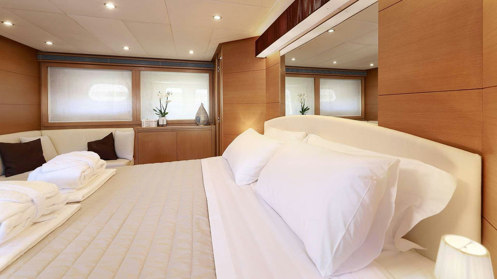 a room with a bed and a mirror aboard PHOENIX Yacht for Charter