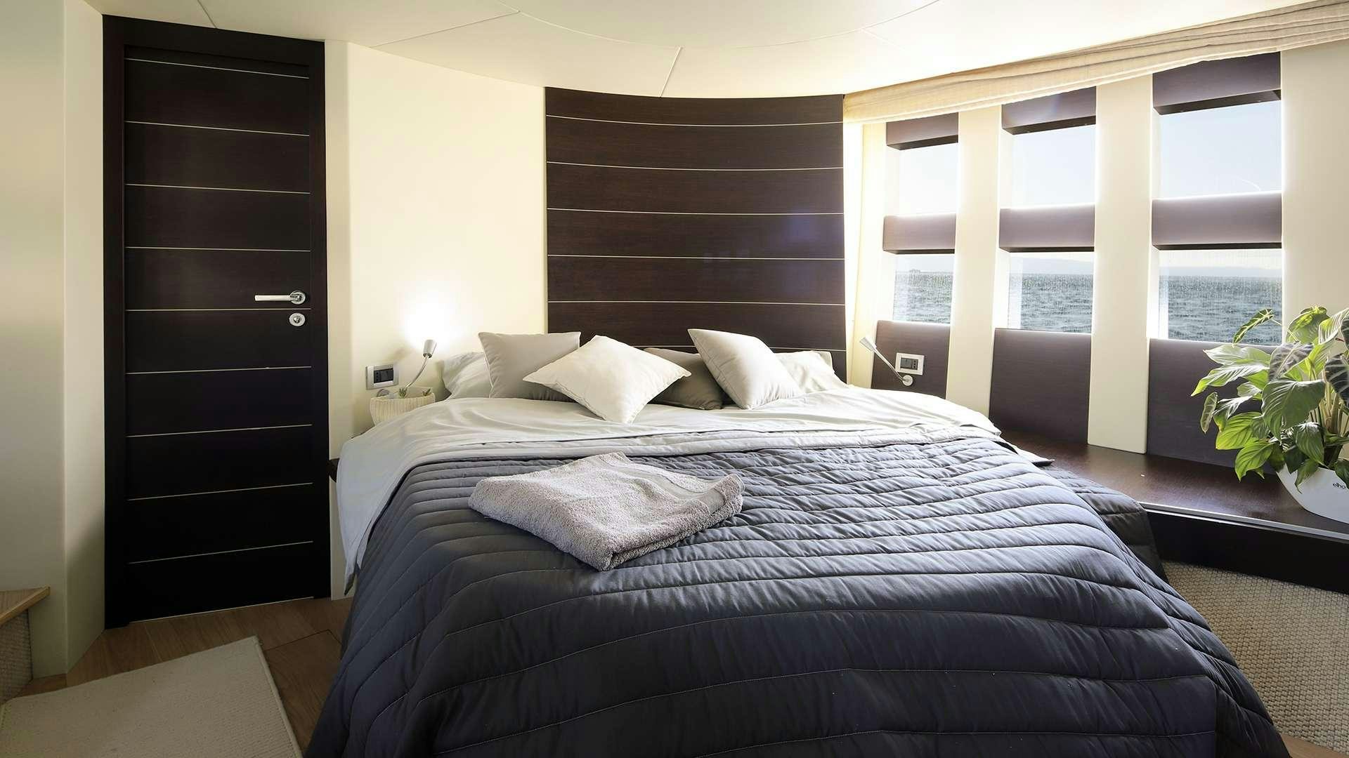 a bed with a black comforter aboard M/Y MAORO Yacht for Charter