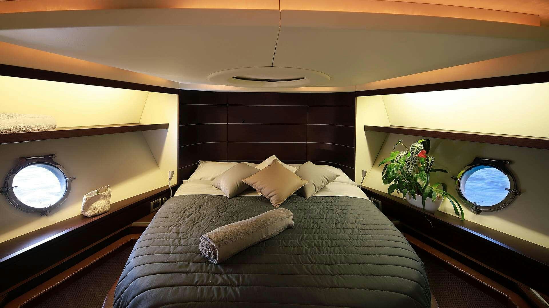 a bed with a round mirror above it aboard M/Y MAORO Yacht for Charter