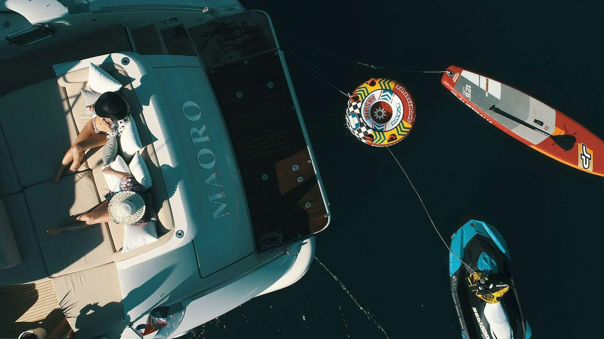 a person in a white dress and hat sitting in a cockpit aboard M/Y MAORO Yacht for Charter