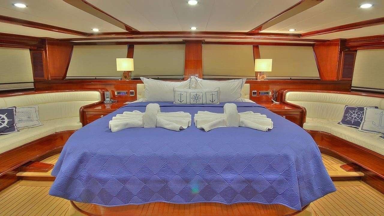 a room with a bed and a lamp aboard PERFORMANCE FEE Yacht for Charter