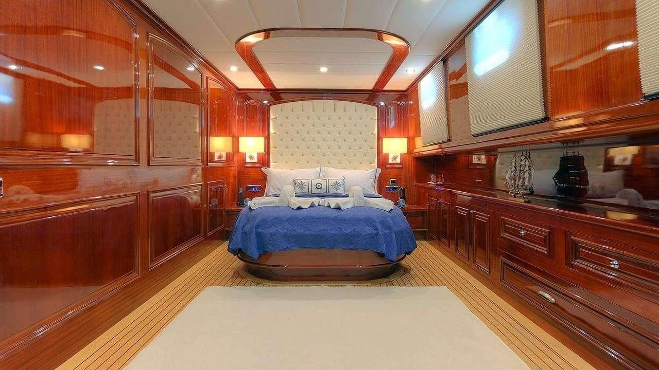 a large room with a bed and a desk aboard PERFORMANCE FEE Yacht for Charter