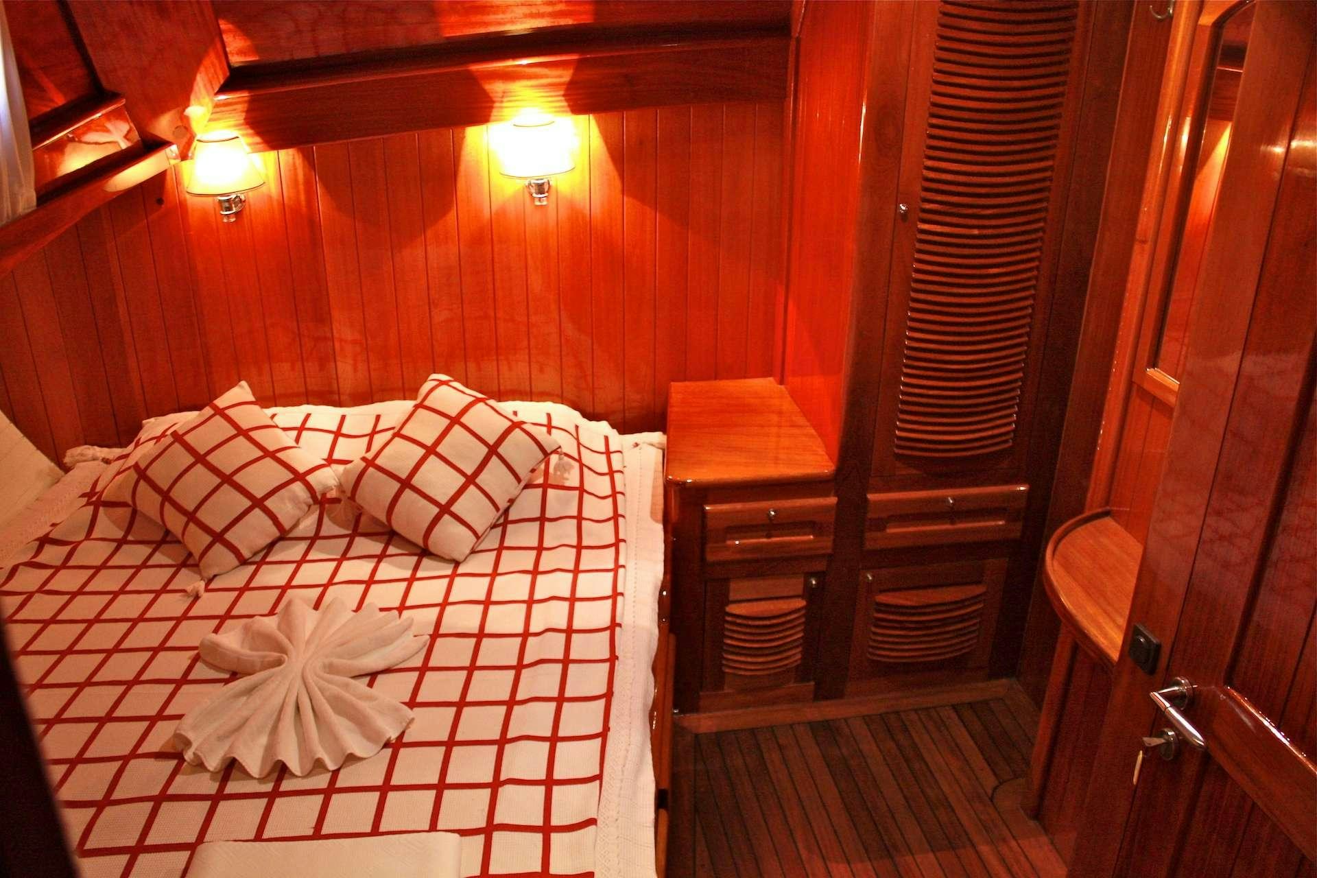 a bed with a red sheet aboard IL FRATELLO Yacht for Charter