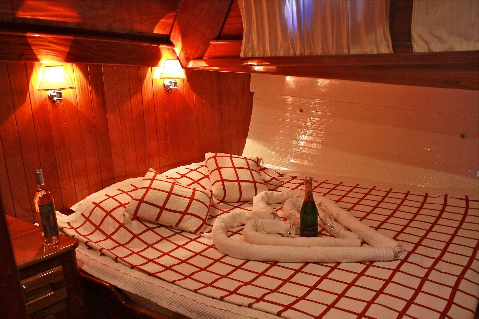 a bottle of wine on a bed aboard IL FRATELLO Yacht for Charter