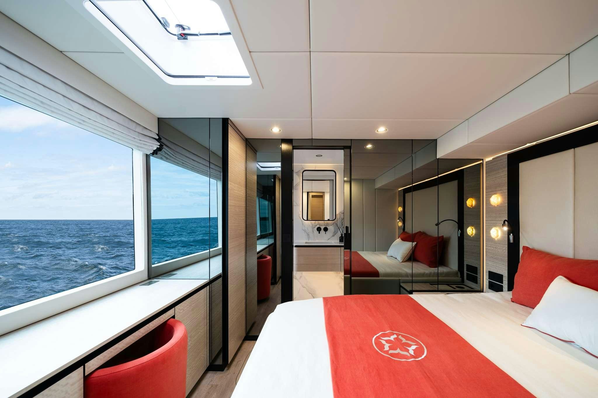 a room with a bed and a large window aboard ONE PLANET Yacht for Charter