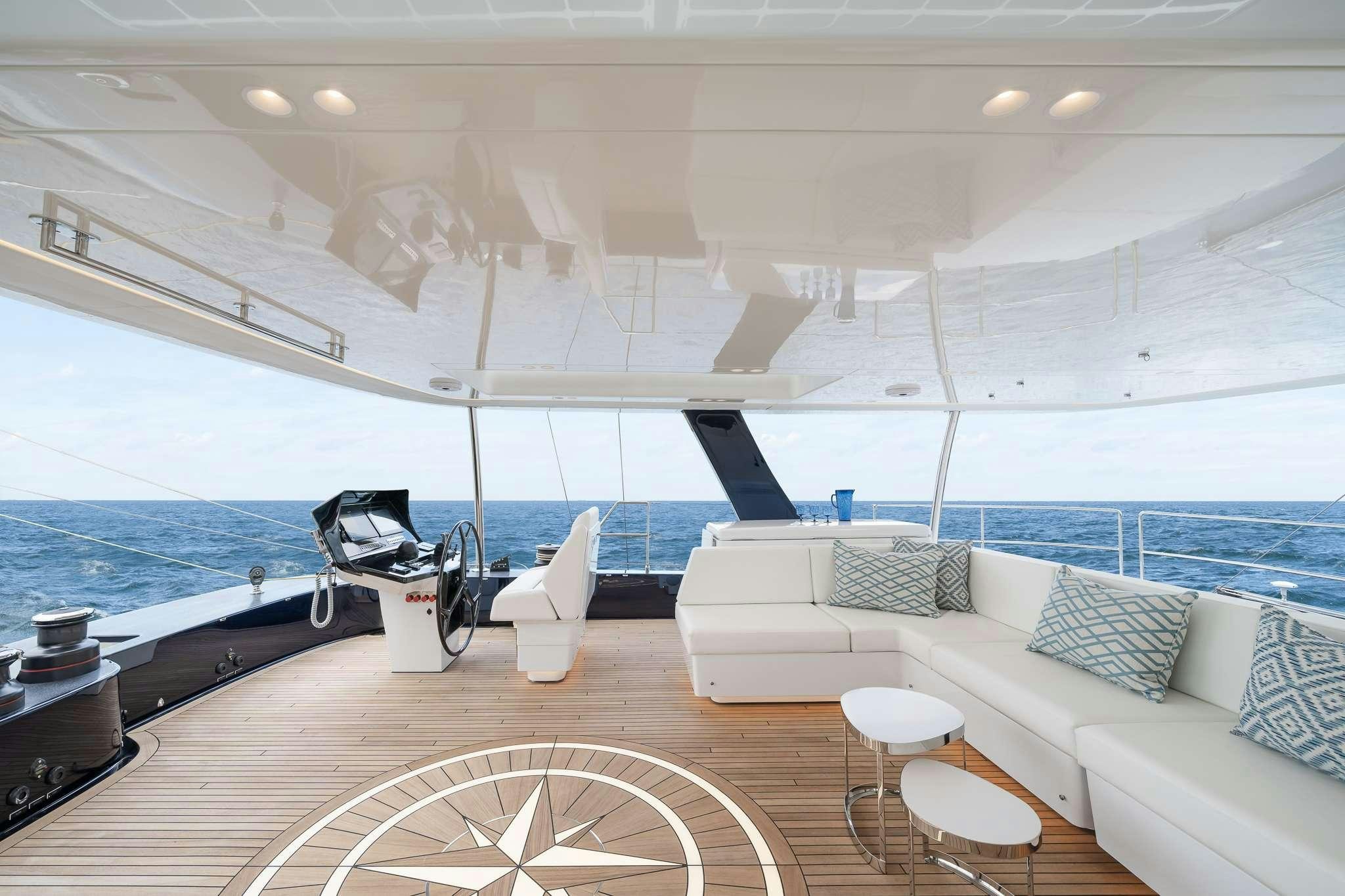 a boat with a couch and a table and chairs on the deck aboard ONE PLANET Yacht for Charter