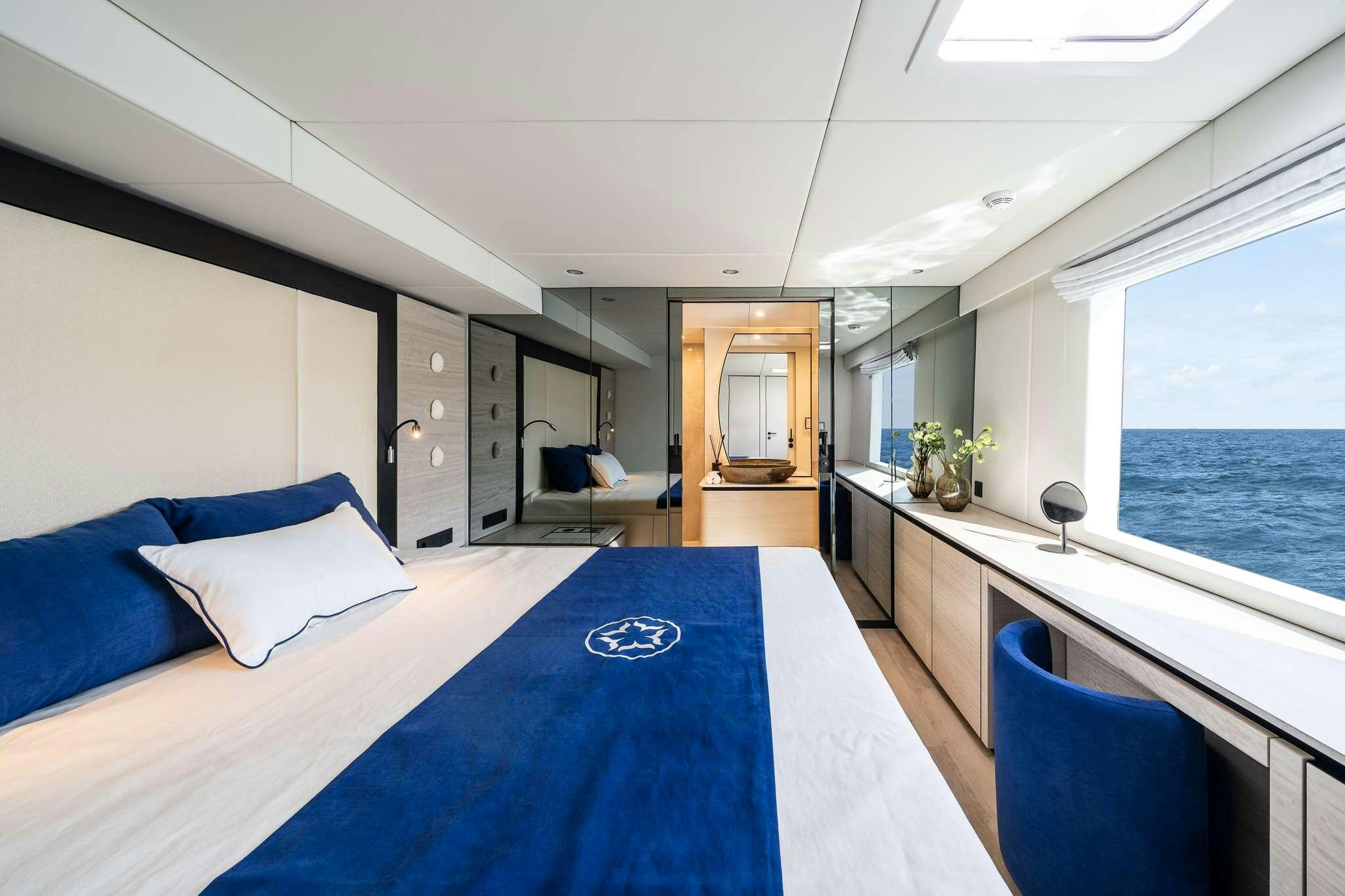 a large room with a large blue table and a large window aboard ONE PLANET Yacht for Charter