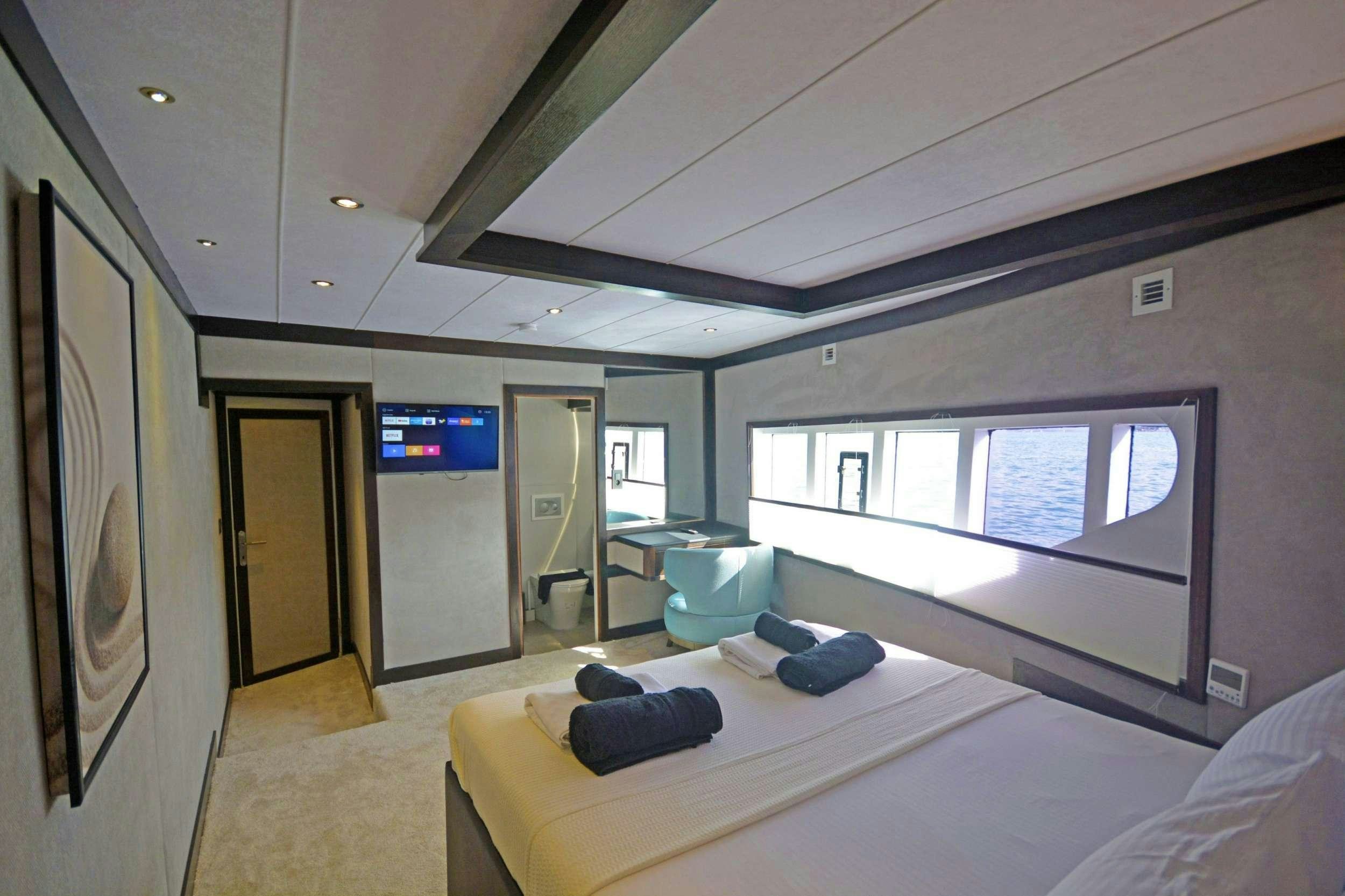 a room with a bed and a large window aboard NAYK 3 Yacht for Charter