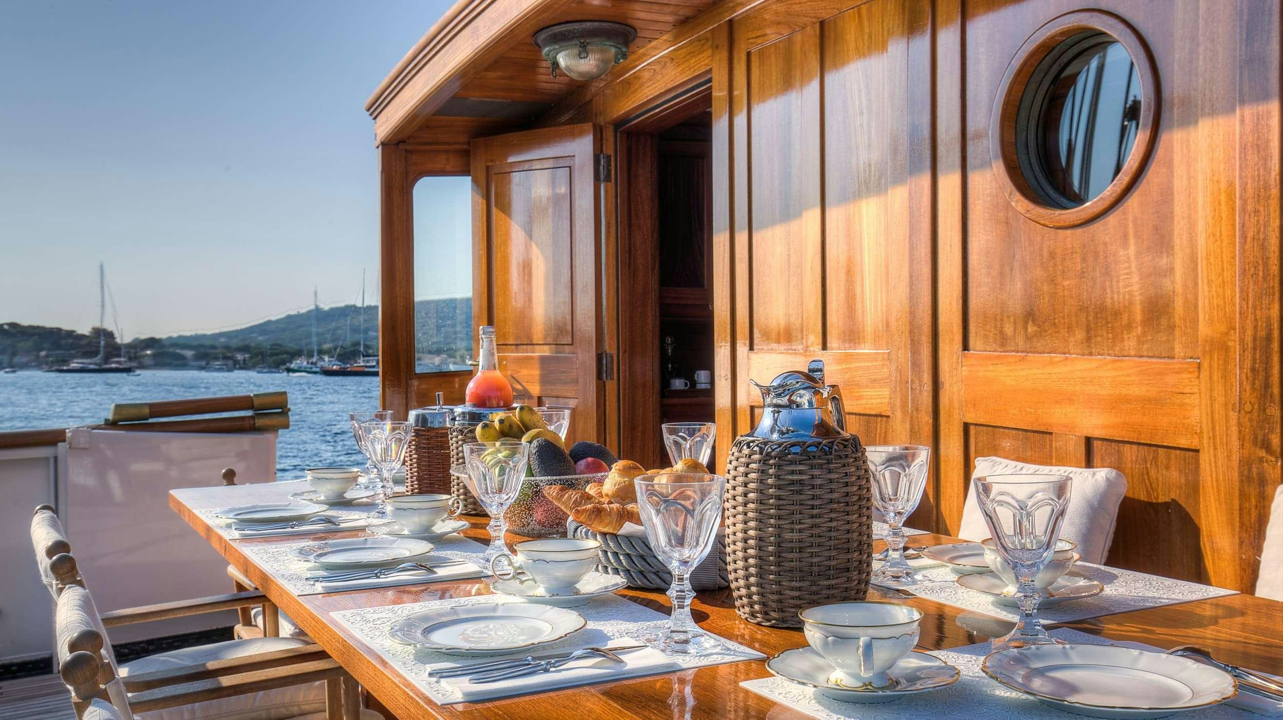 a table with plates and glasses on it aboard TRINAKRIA Yacht for Charter