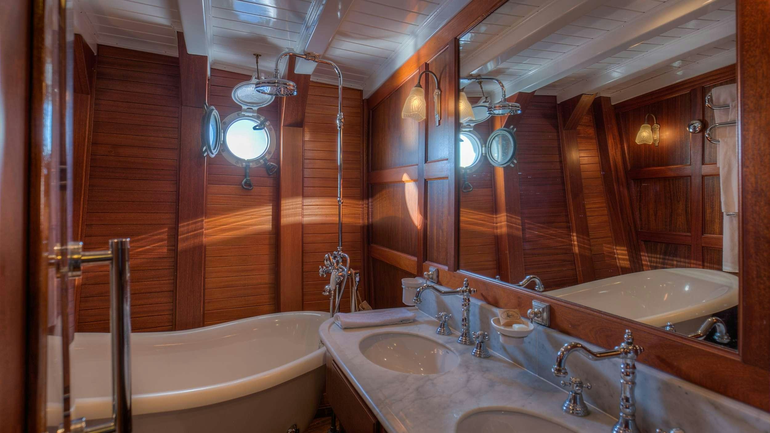 a bathroom with a sink and a bathtub aboard TRINAKRIA Yacht for Charter
