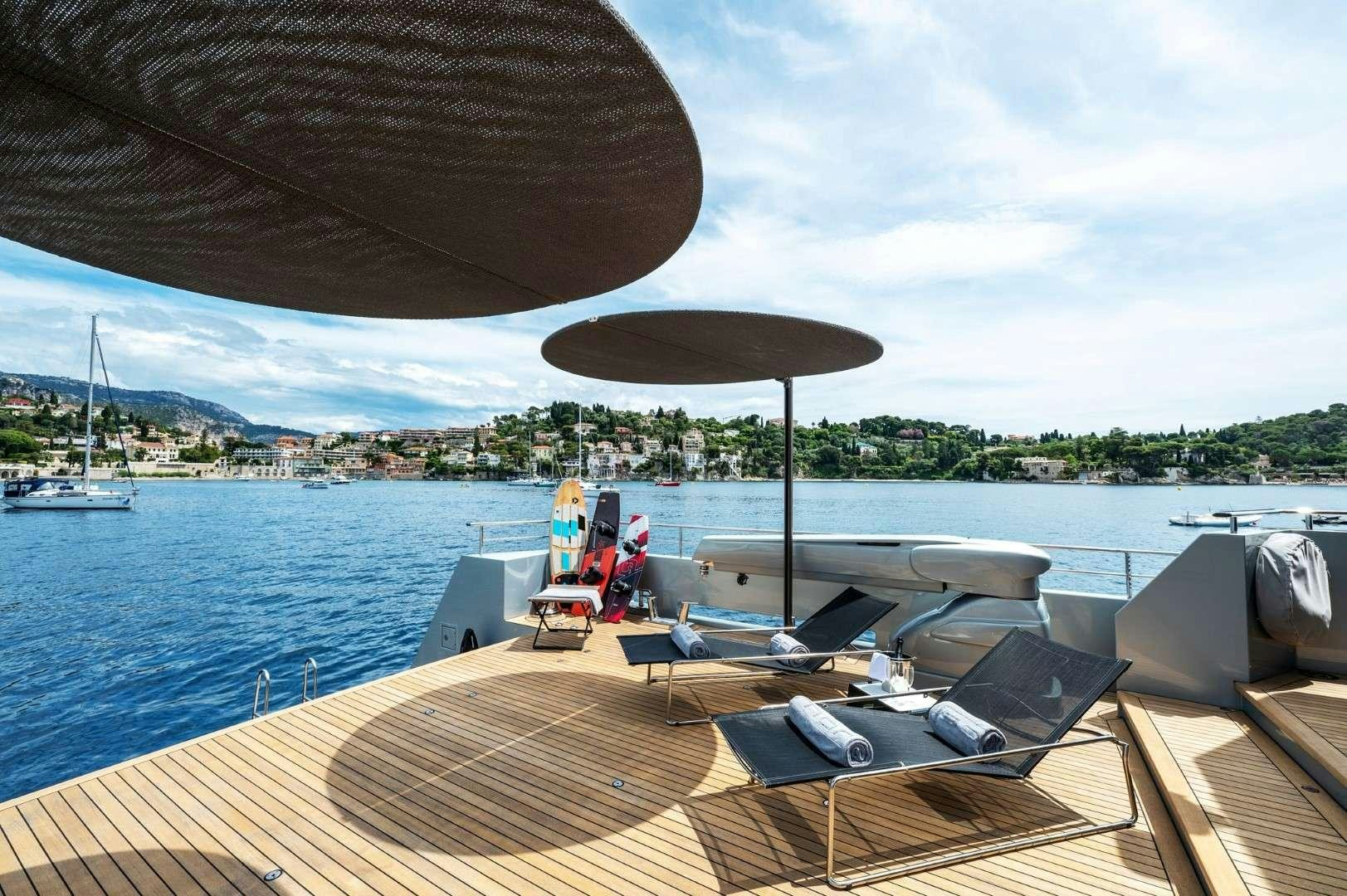 a deck with a boat and a large umbrella on it aboard SO'MAR Yacht for Charter