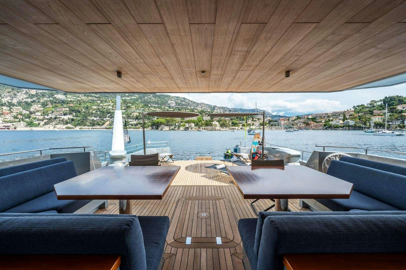 a deck with a view of a body of water and a boat in the water aboard SO'MAR Yacht for Charter