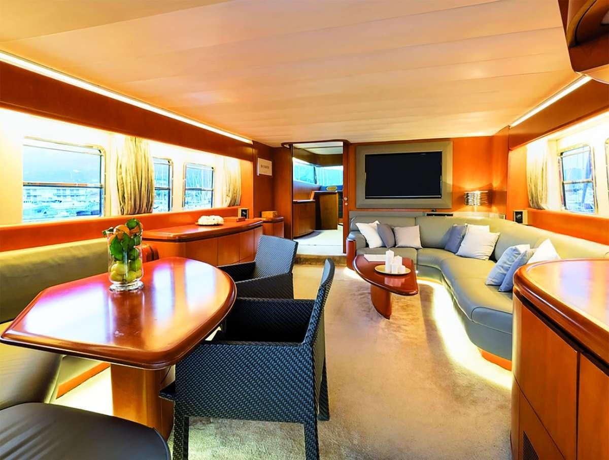a living room with a table chairs and a tv aboard CLAUDIA AMBER Yacht for Charter