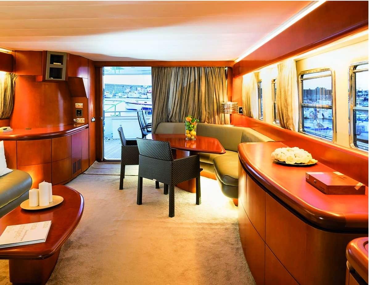 a living room with a table and chairs aboard CLAUDIA AMBER Yacht for Charter