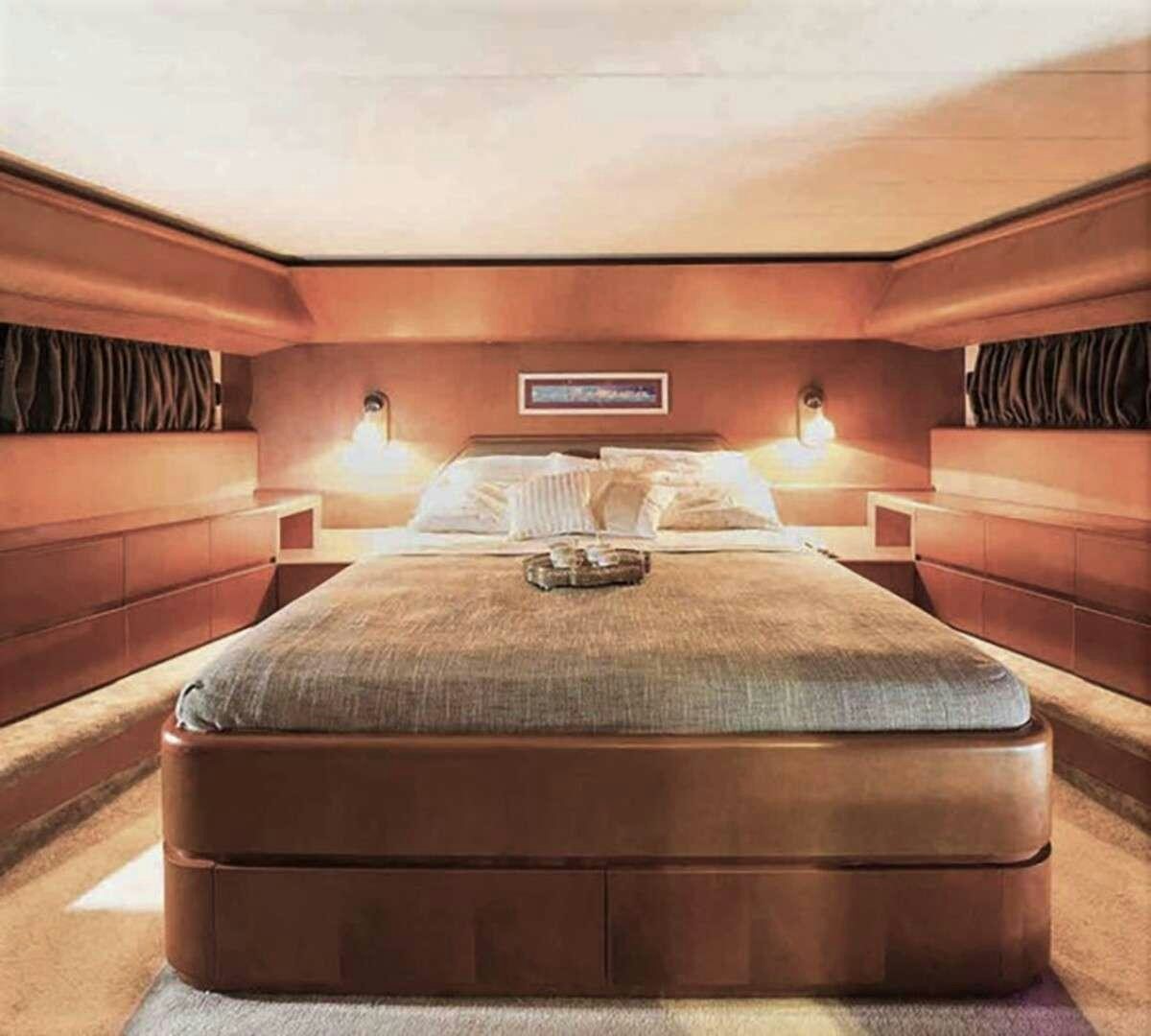 a bed with a black and white comforter and a red wall aboard CLAUDIA AMBER Yacht for Charter