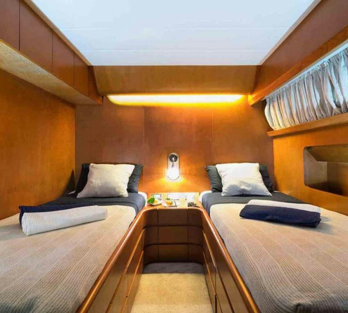 a room with beds and a table aboard CLAUDIA AMBER Yacht for Charter