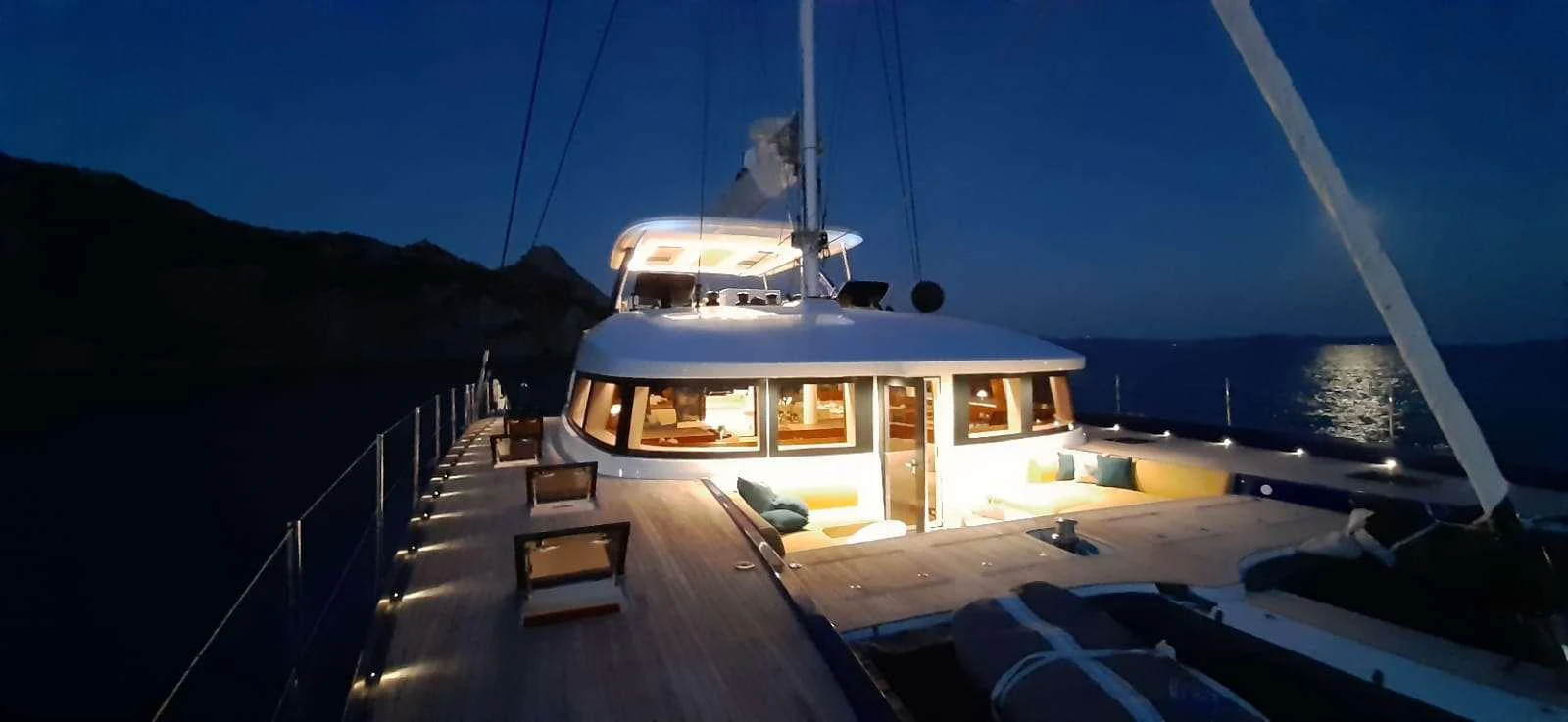 The yacht's aft deck is beautifully illuminated at dusk, showcasing a serene and inviting atmosphere. aboard NEFESH Yacht for Charter